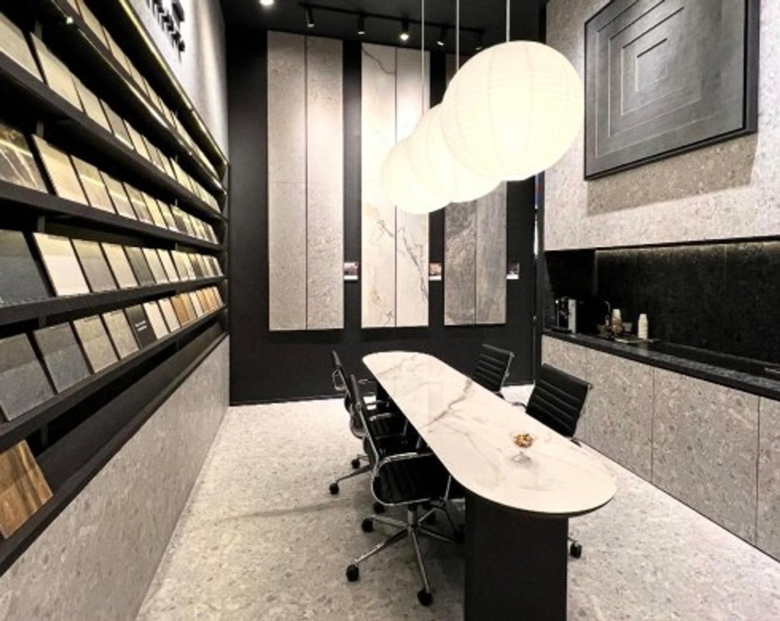 Oficina moderna con mesa de conferencias y luces colgantes — proyecto Expo Revestir 2026, por Vite Porcellanato, en São Paulo