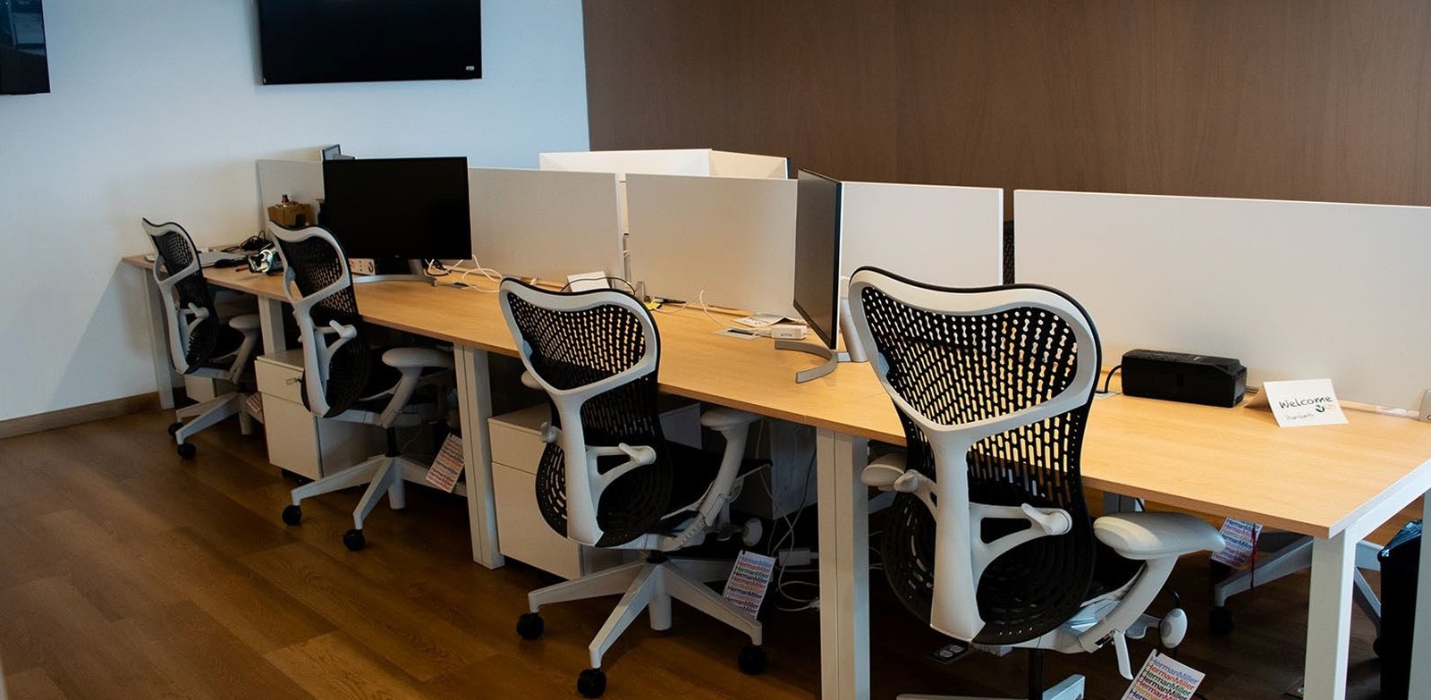 Escritório moderno com estações de trabalho em fila e mesas de madeira clara — projeto oficinas voicess// polanco / atlantico arqs, por atlantico arqs, em Polanco