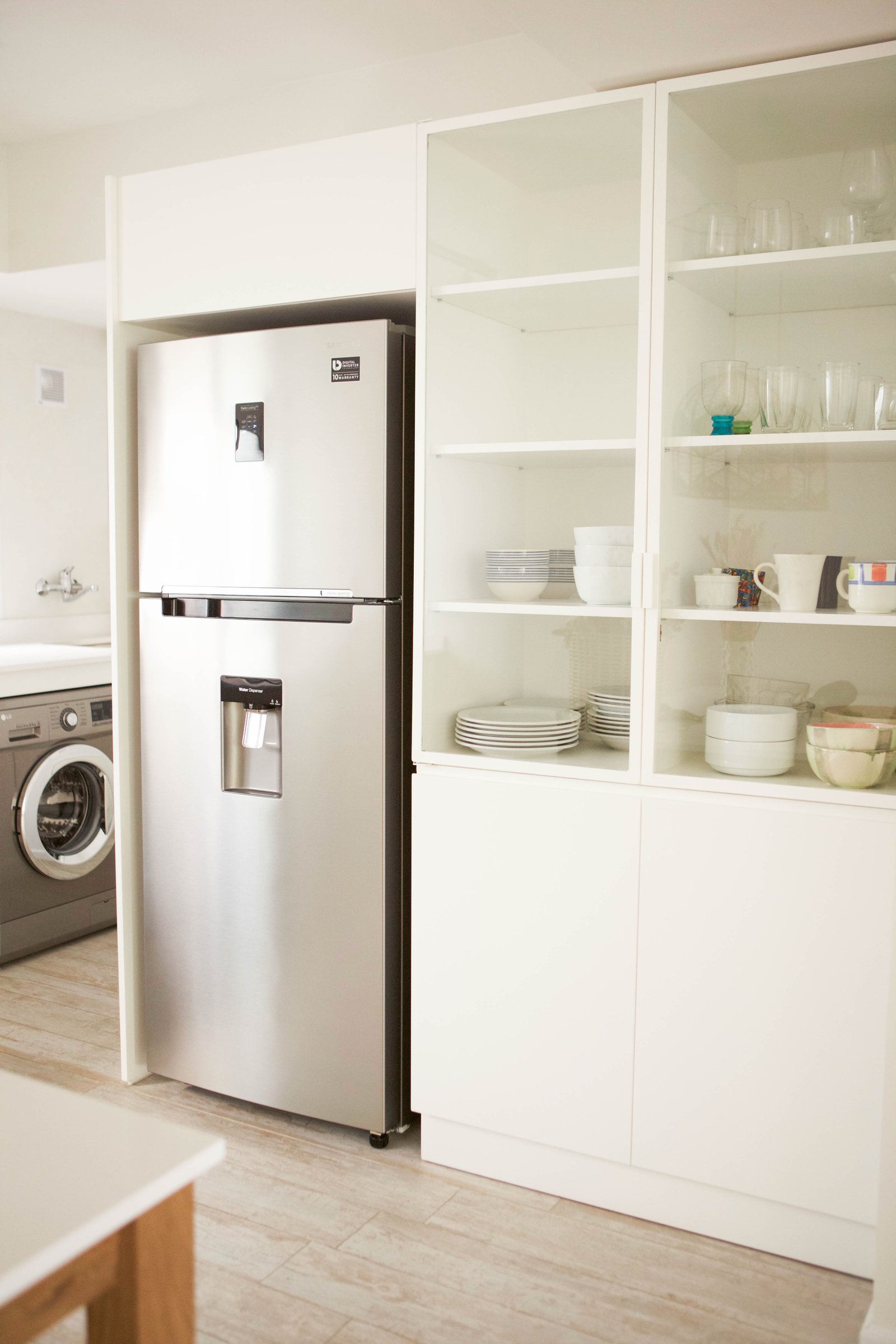 Cocina moderna con refrigerador de acero inoxidable y estantería blanca con puertas de vidrio — proyecto Araujo, por LACROZE DESIGN STUDIO, en Núñez