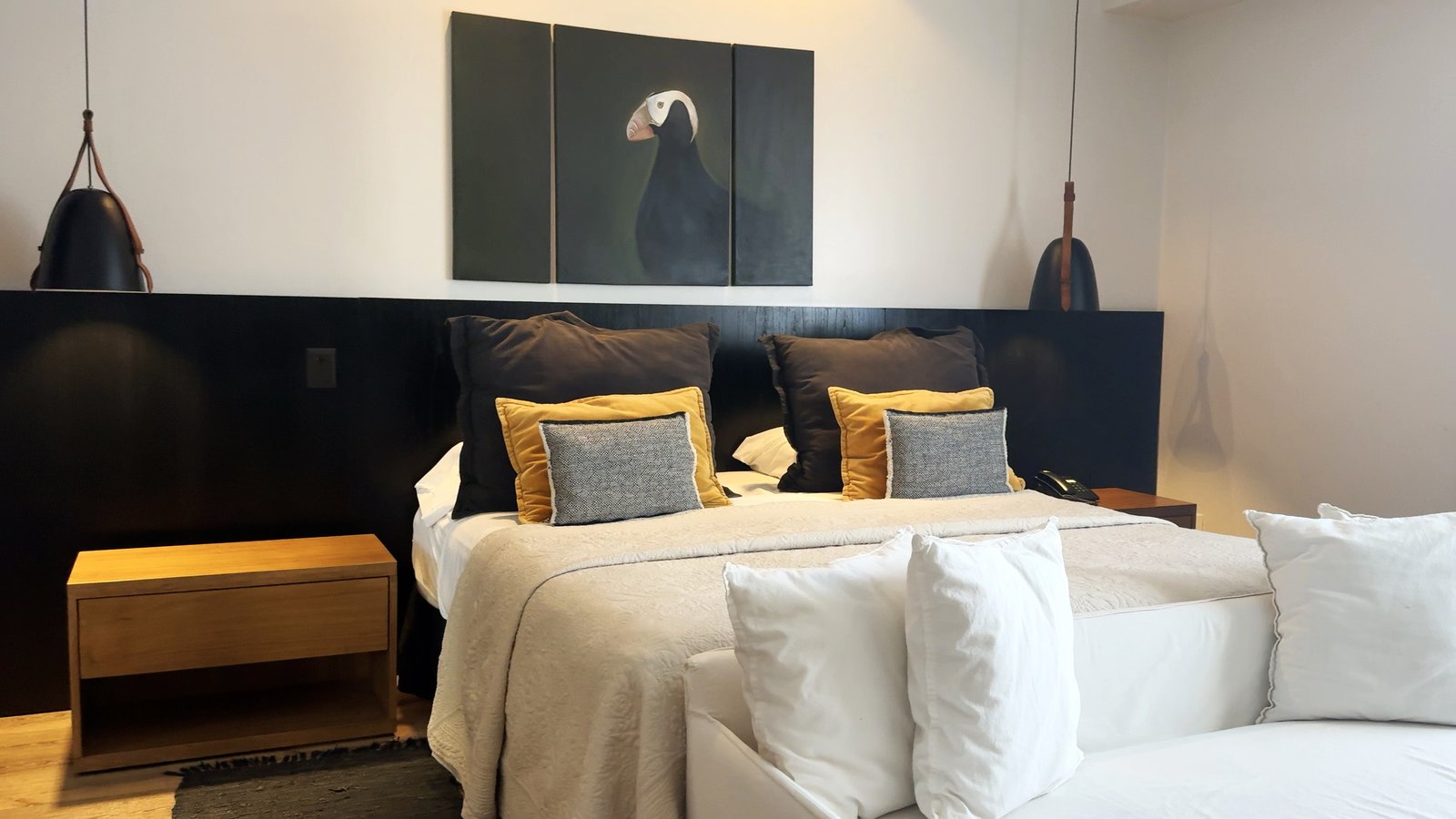 Quarto moderno com arte de pássaro e luminárias pendentes — projeto Villa Isidro Hotel Boutique & Spa, por Hermann Arquitectos, em San Isidro