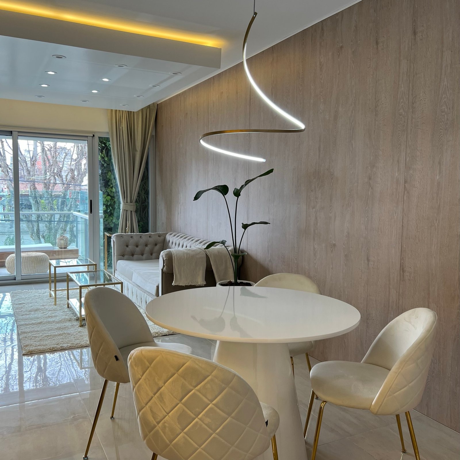 Comedor moderno con mesa redonda blanca y sillas tapizadas — proyecto Basualdo I, por MDBK Arquitectura, en Liniers