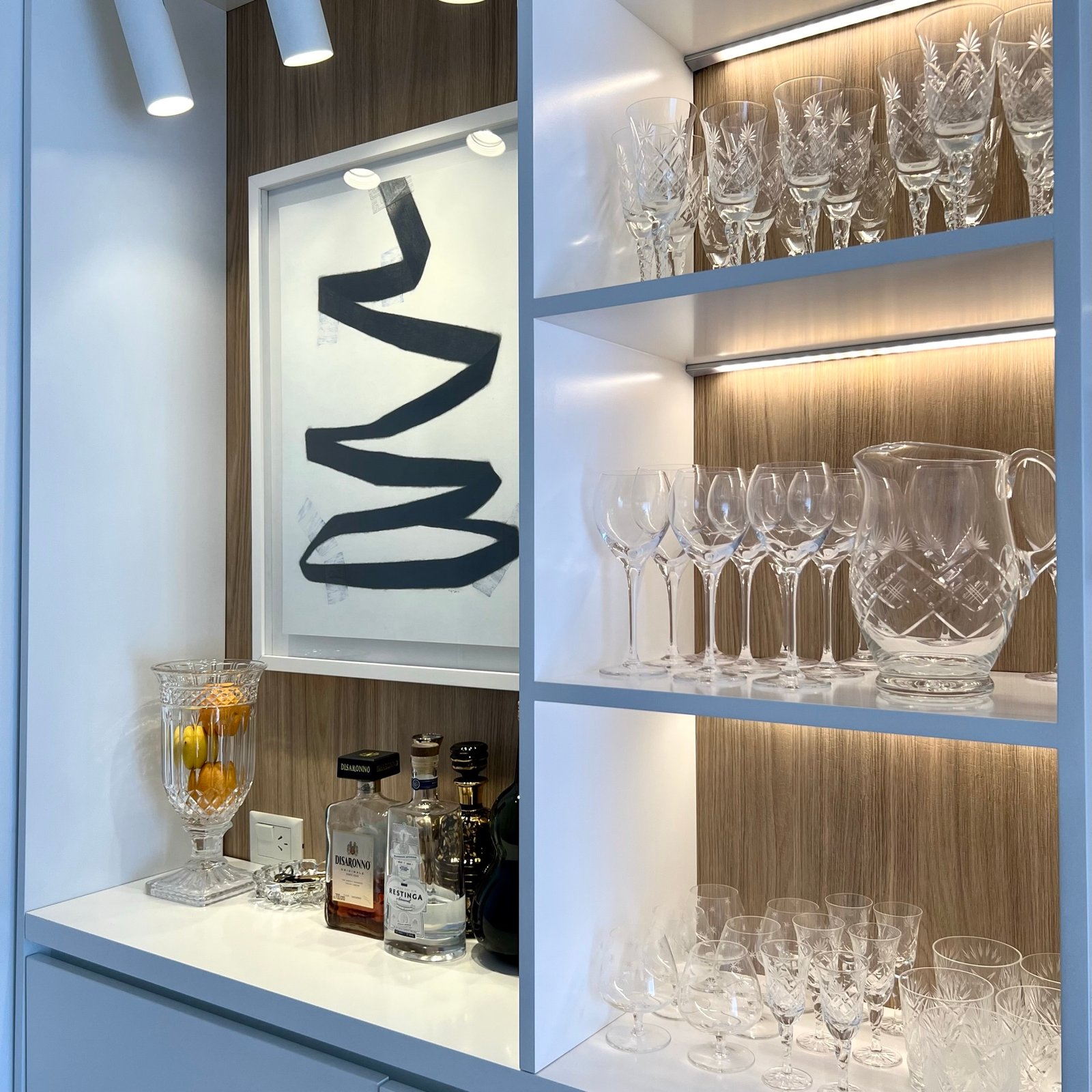 Bar moderno com prateleiras de vidro e arte abstrata — projeto Cramer I, por MDBK Arquitectura, em Belgrano