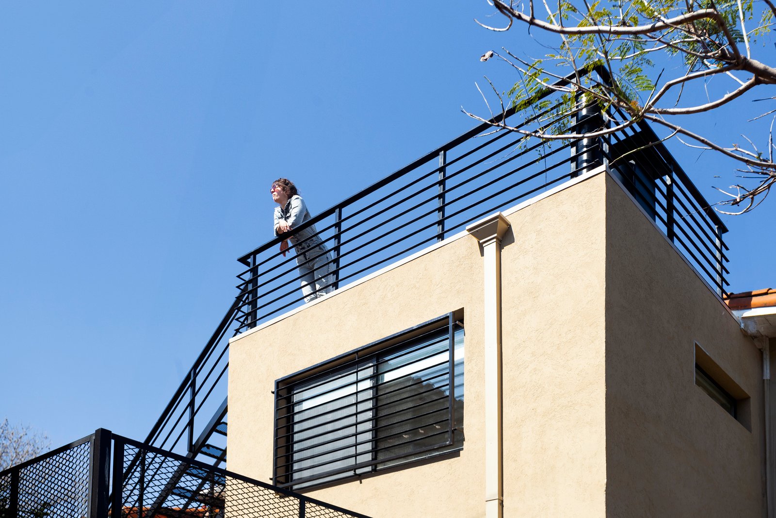Terraza de azotea moderna con persona y ventanal de hormigón — proyecto LAPRIDA, por La Nave Arq., en Vicente López