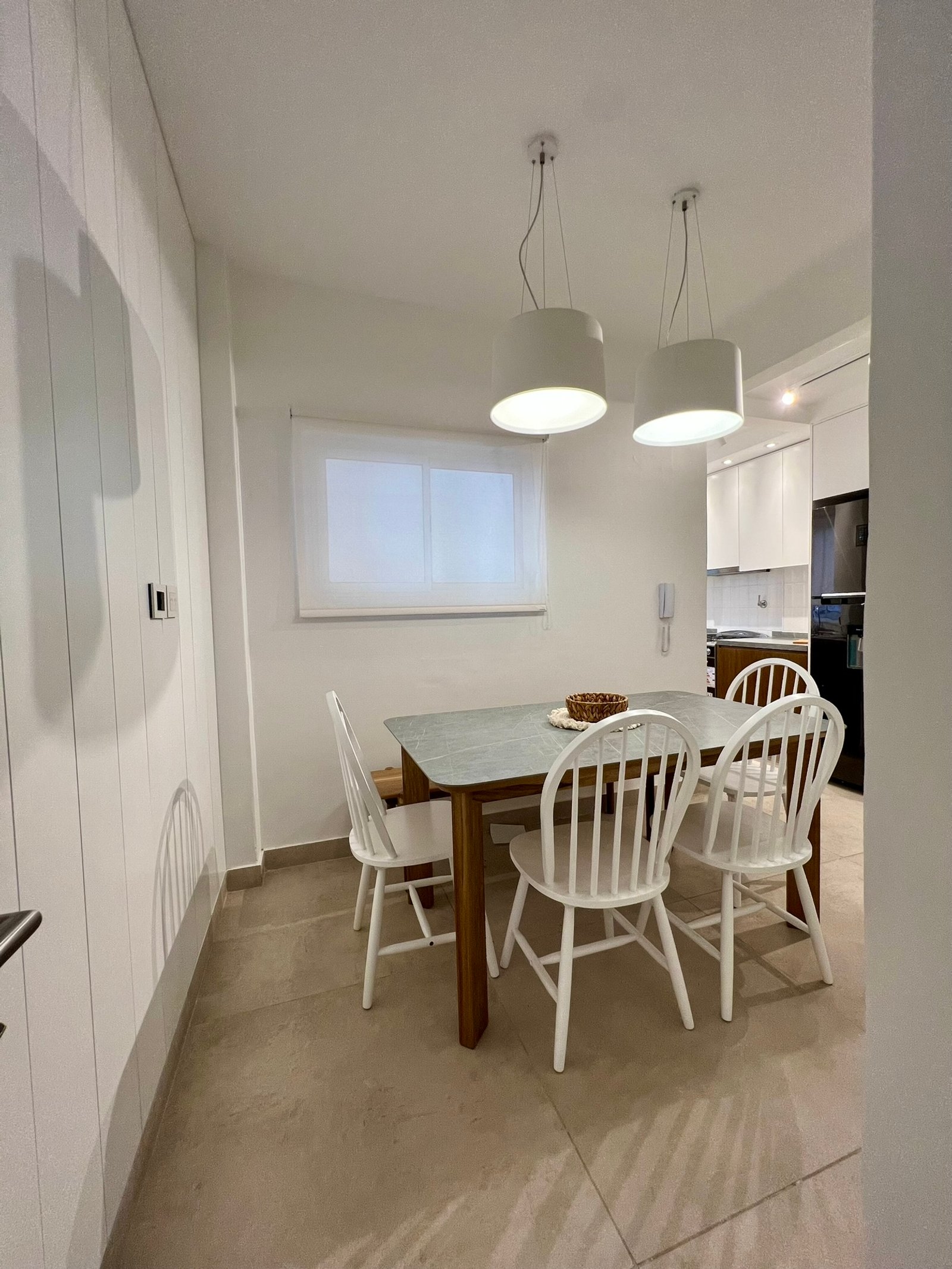 Comedor moderno con mesa de madera y sillas blancas — proyecto Perón , por MDBK Arquitectura, en Barrio Norte