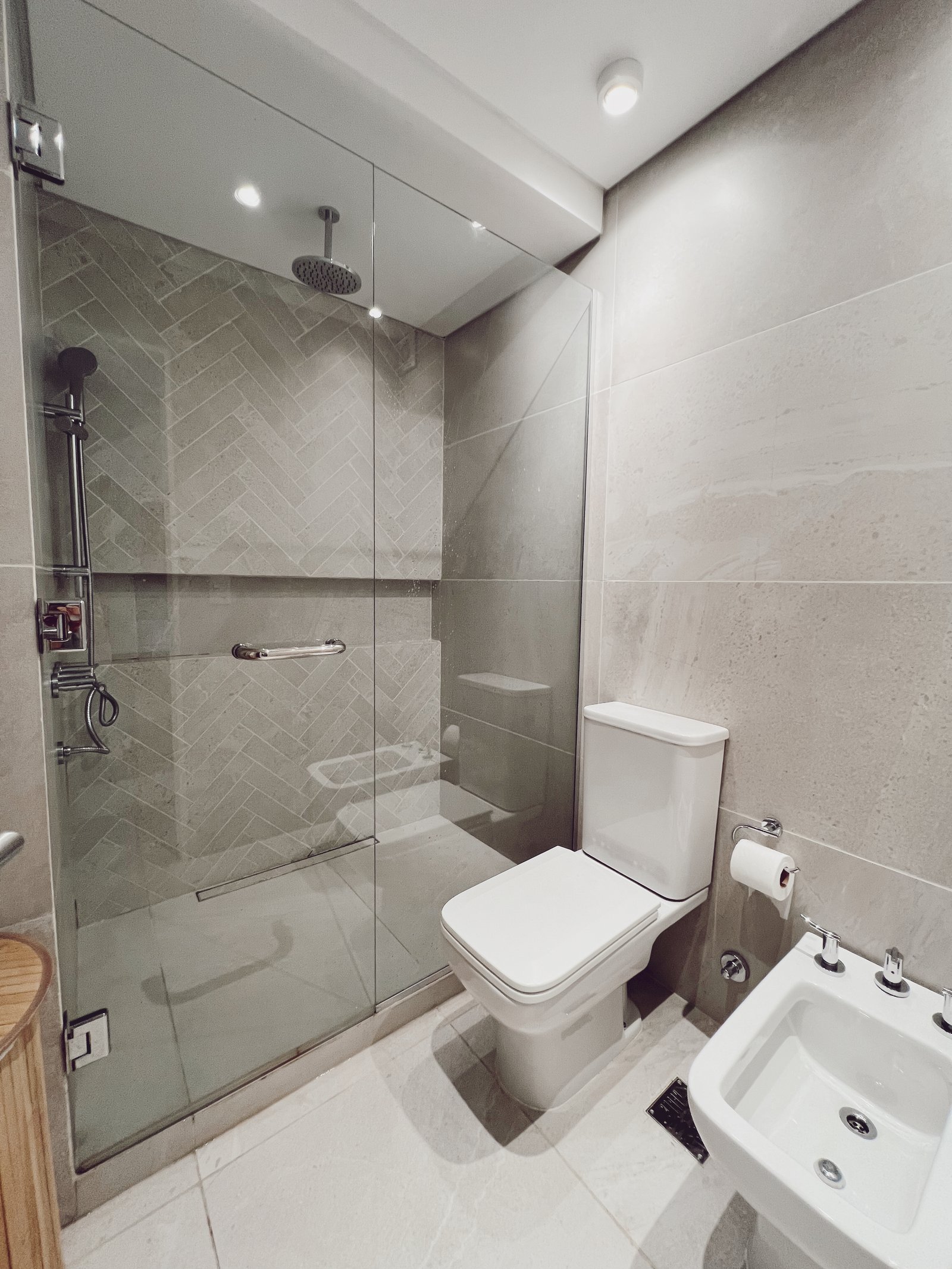 Banheiro moderno com box de vidro, vaso sanitário e bidê — projeto Libertador, por Equipe, em Buenos Aires