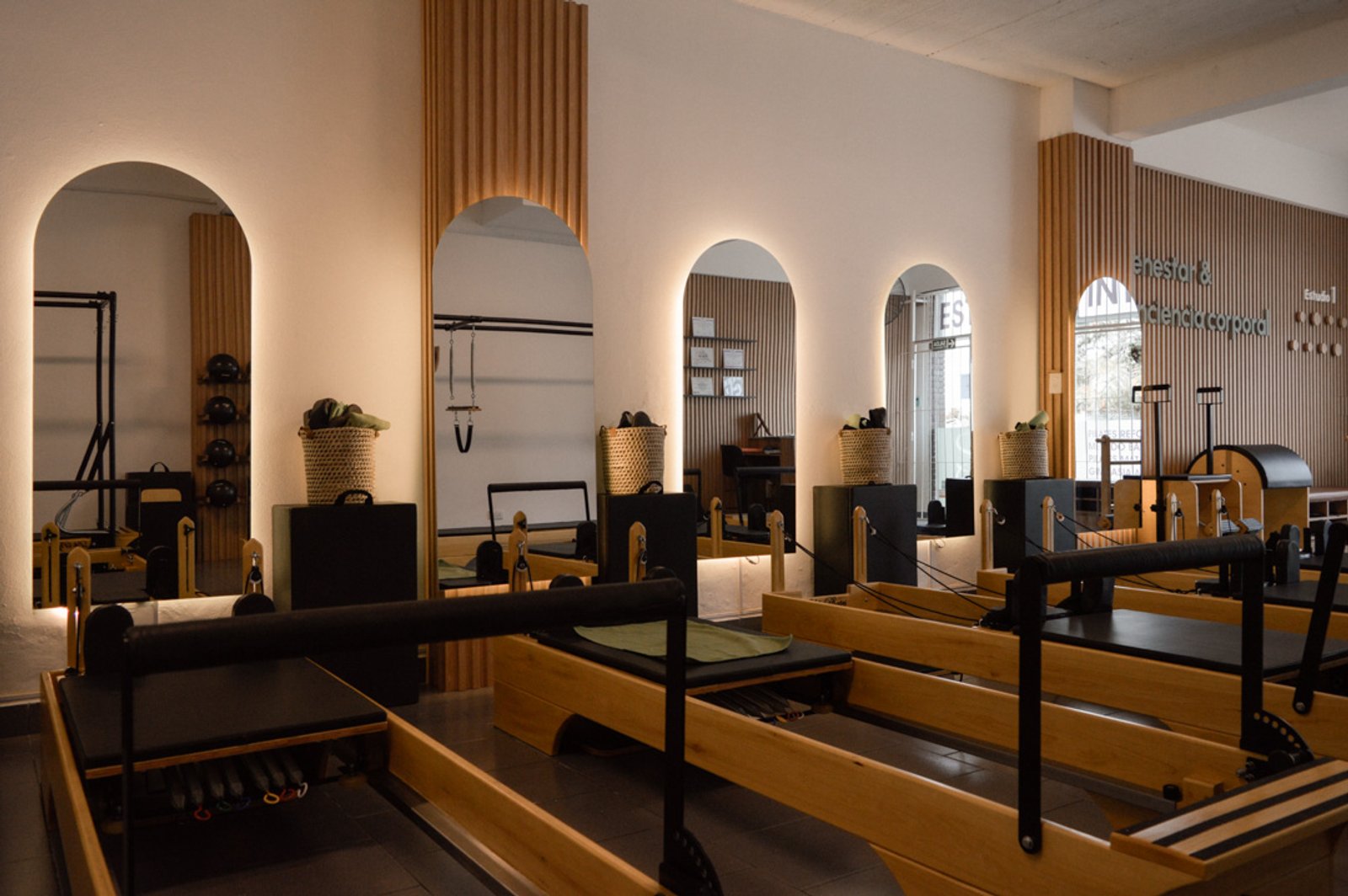 Estudio de pilates moderno con máquinas de madera y detalles de listones — proyecto Estudio Integral SC - Tandil, por Estudio Agustina Satostegui, en Tandil