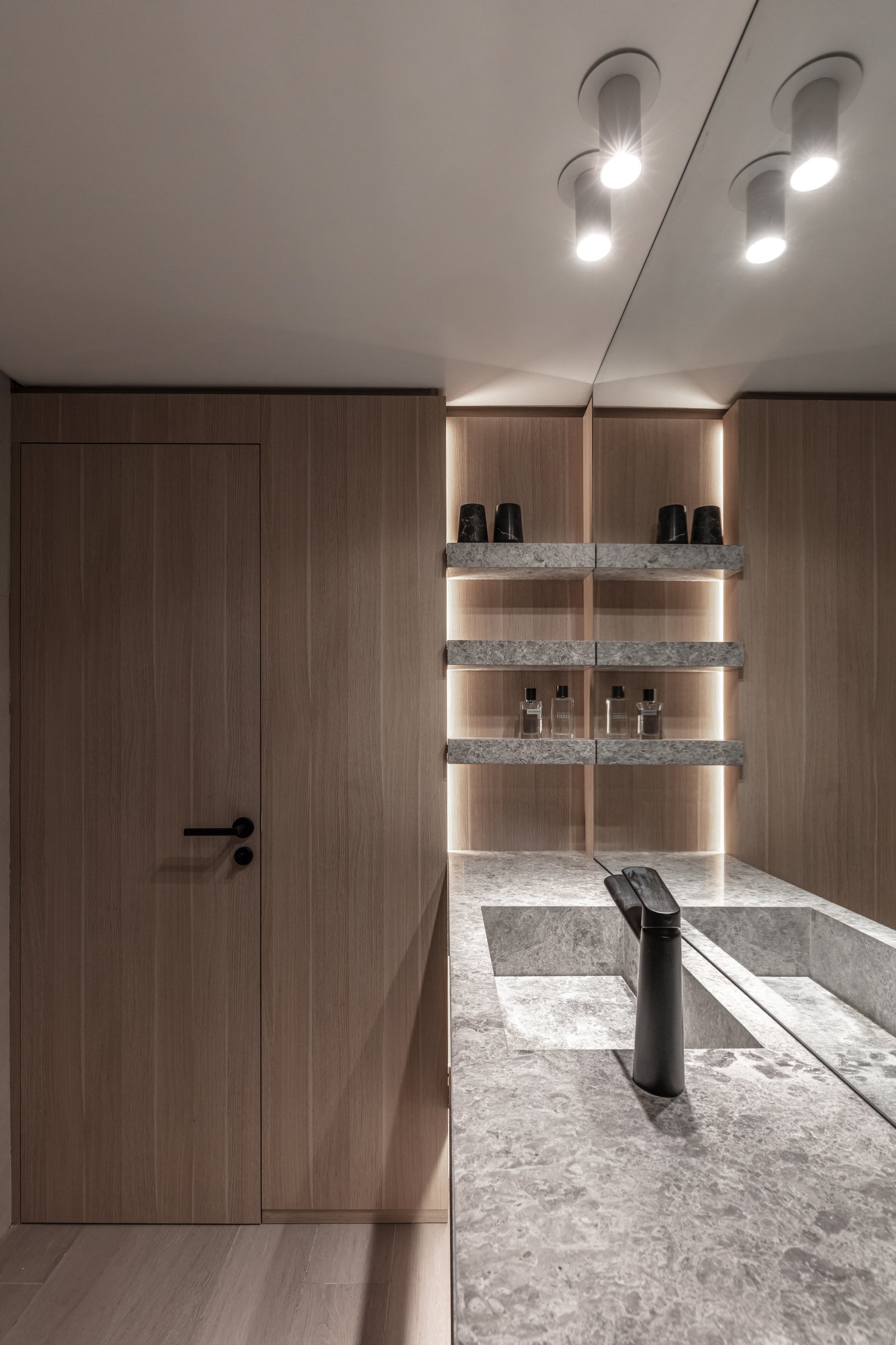 Baño moderno con paredes de madera, encimera de piedra gris y grifería negra — proyecto Eslovenia | Pied-à-terre | Lucia Quinteros, por Ren Studio, en Cdad. Autónoma de Buenos Aire