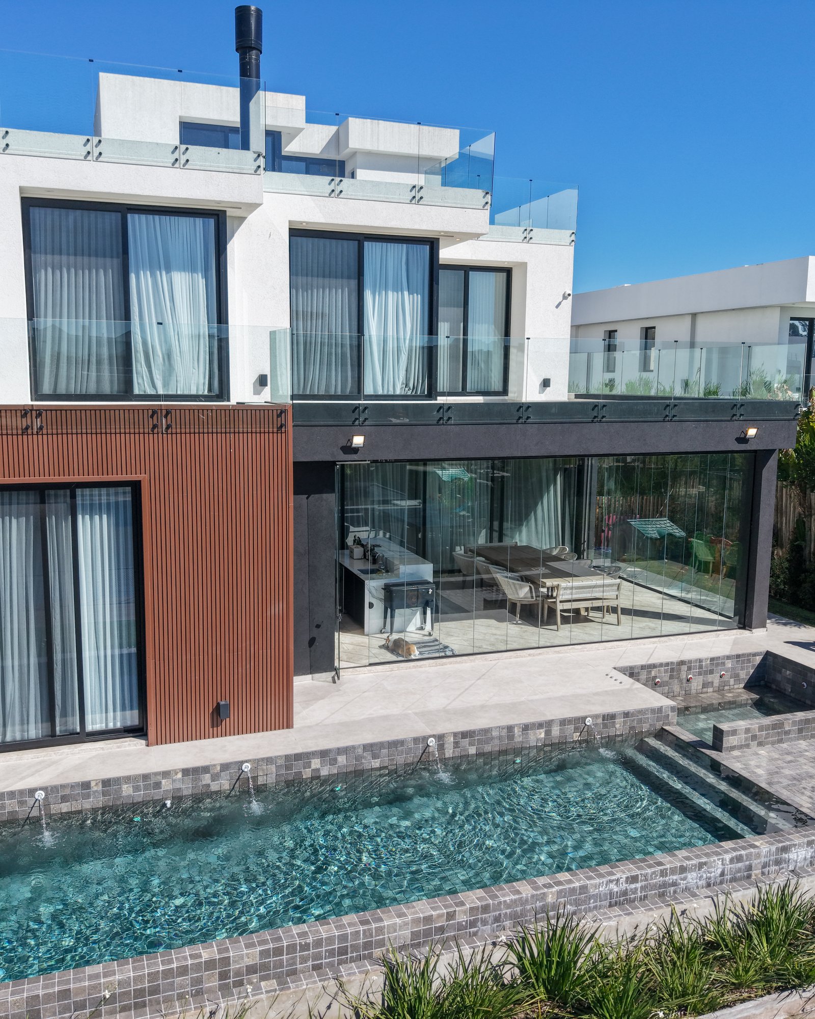 Fachada moderna con piscina y terraza de madera — proyecto Yatch 278, por CIFARELLI arquitectos, en Tigre