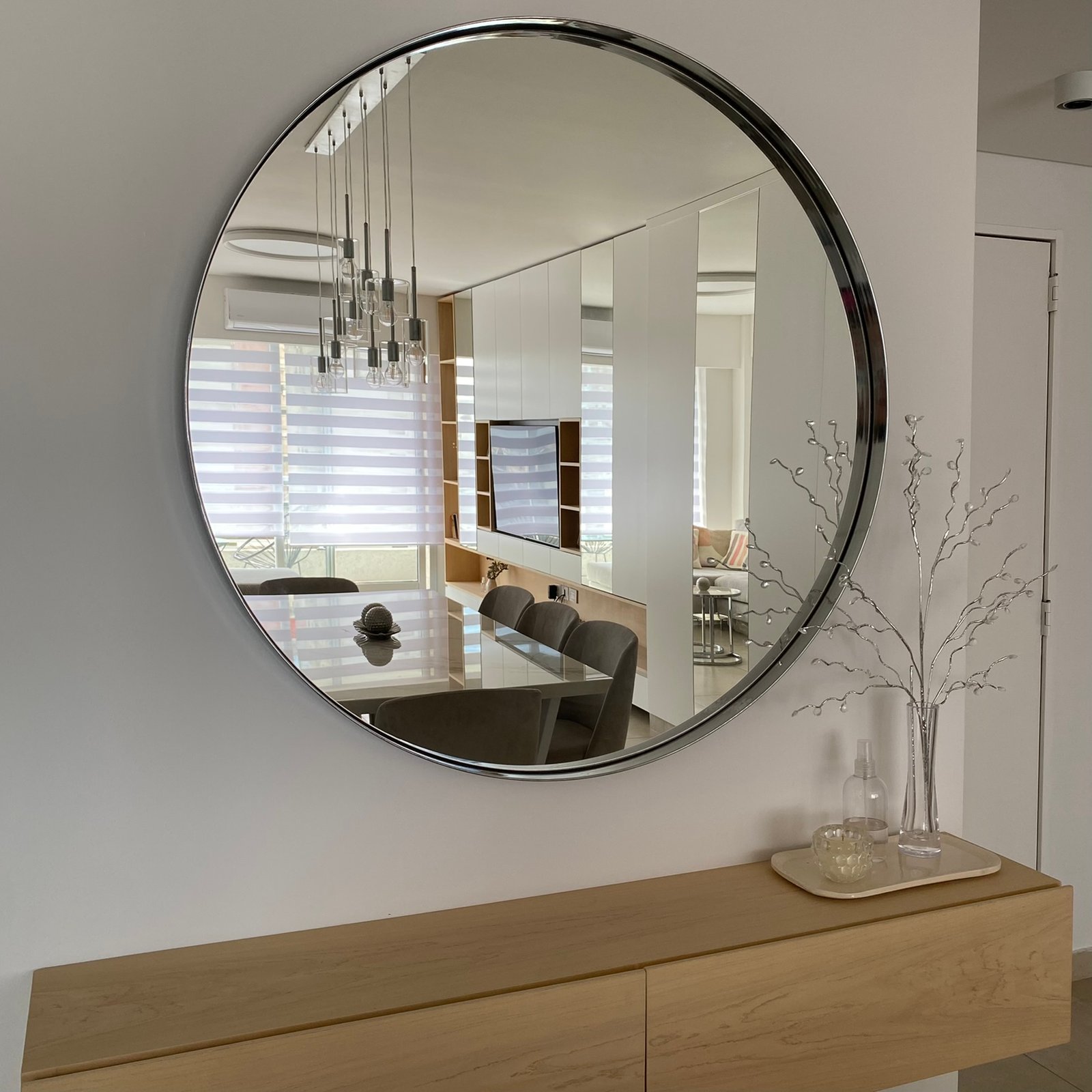 Comedor moderno con espejo redondo grande y mesa de madera — proyecto Padilla, por MDBK Arquitectura, en Villa Crespo
