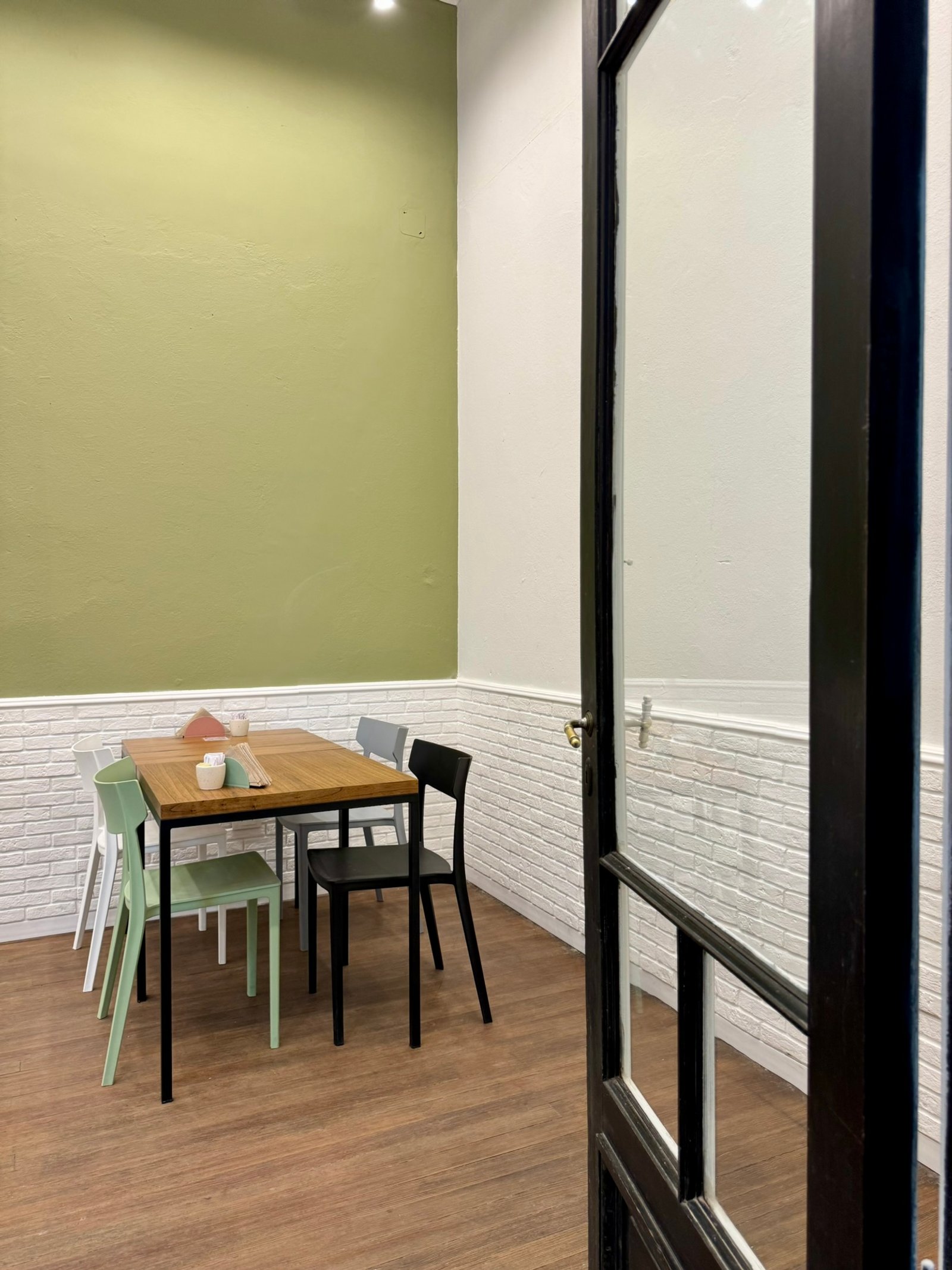 comedor moderno con pared verde y ladrillo blanco — proyecto UGA Coffee House, por MDBK Arquitectura, en Almagro