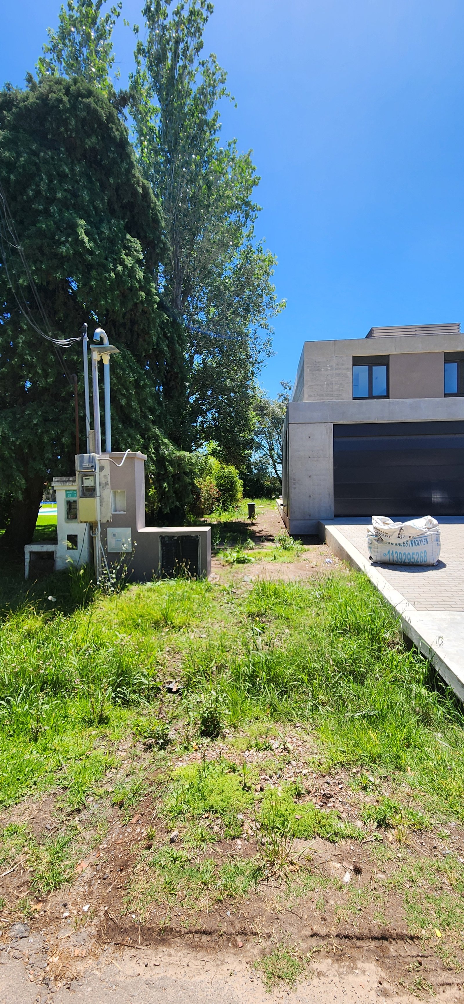 Fachada moderna de hormigón visto, obra en progreso, zona verde — proyecto Casa CAD, por Estudio Rifahi, en Moreno