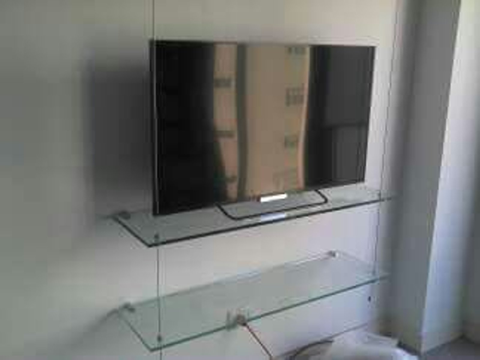 Sala de estar minimalista con tv y estantes de vidrio flotantes — proyecto Estantes con cabletensores y varios, por Cristalcenter, en Palermo