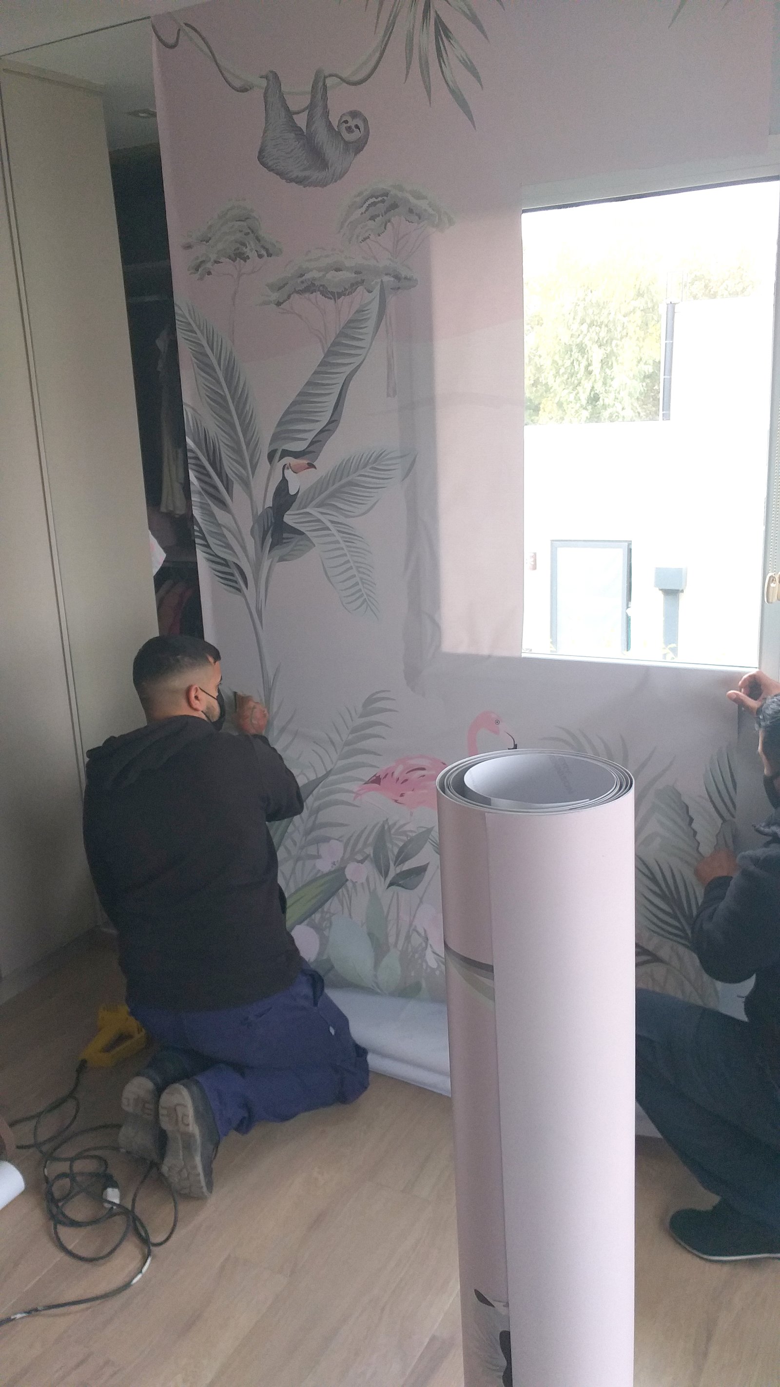 Hombre instalando papel tapiz con diseño tropical y perezoso — proyecto Mural flamencos, por Picma Empapelados, Murales, Esmerilados, Prints ,Papeles, en Canning