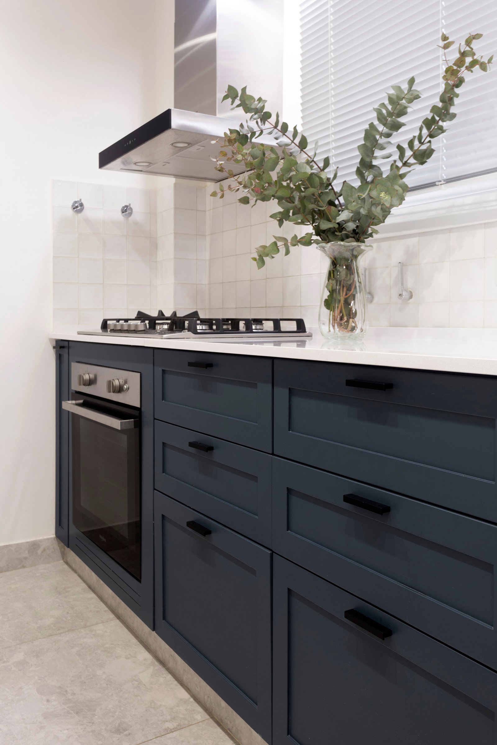 Cocina moderna con gabinetes azul oscuro y encimeras de mármol — proyecto Paraná, por JT ARQUITECTURA, en Buenos Aires