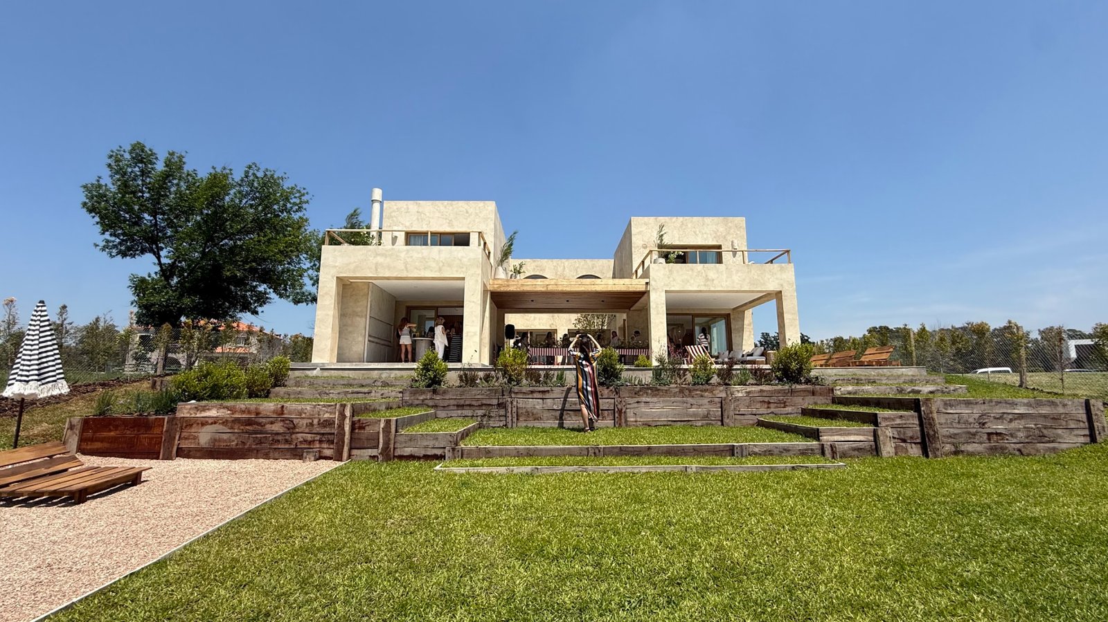 Fachada moderna con deck y pérgola — proyecto La Verbena, por Grupo Pauta Arquitectura, en Alejandro Korn 3150