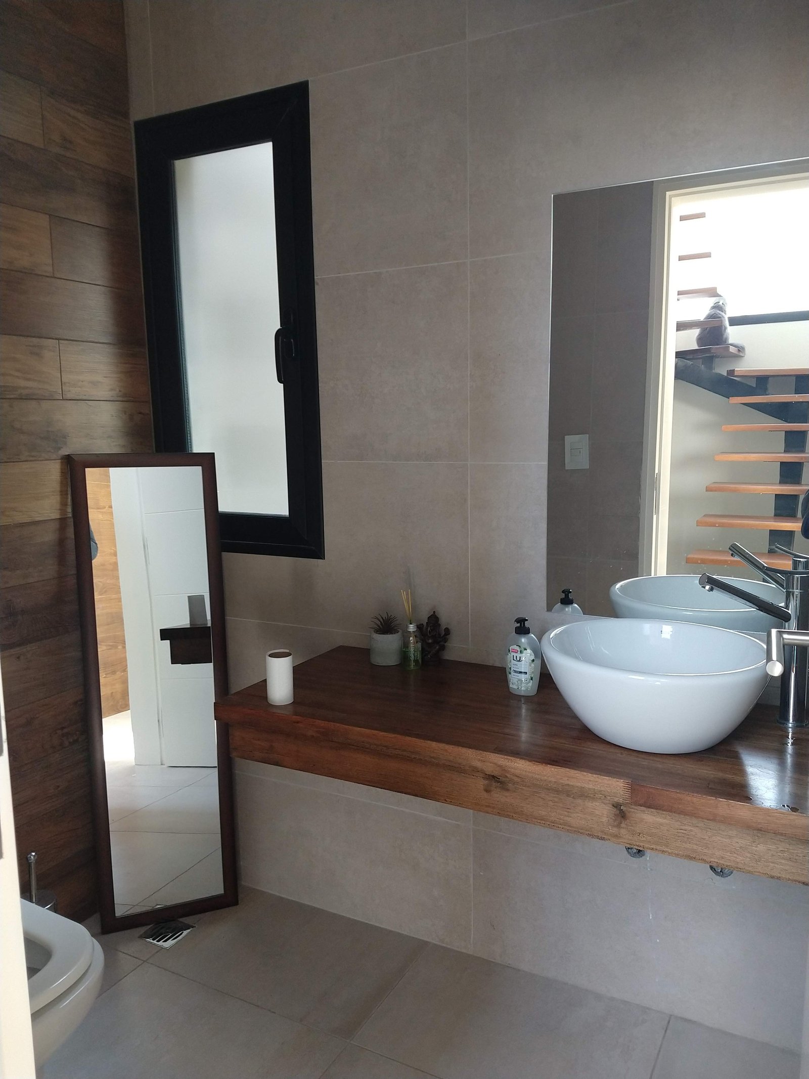 baño moderno con mesada de madera y bacha de apoyo — proyecto Proyecto E-E, por TERROC, en Maipú