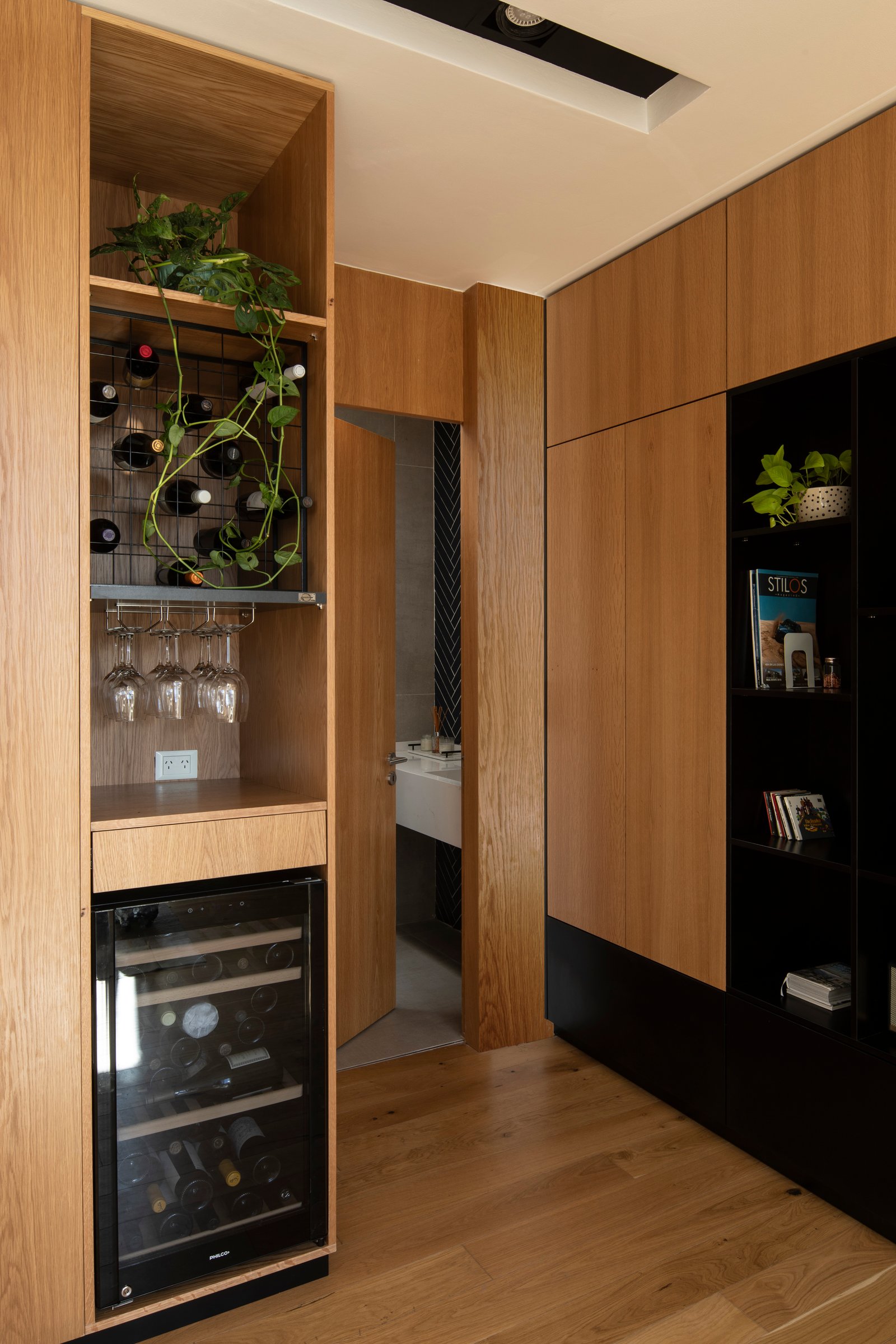 Mueble de cocina integrado de madera natural con bodega y enfriador de vinos — proyecto Casa MECHA, por Grupo CRBN, en B1712 Castelar