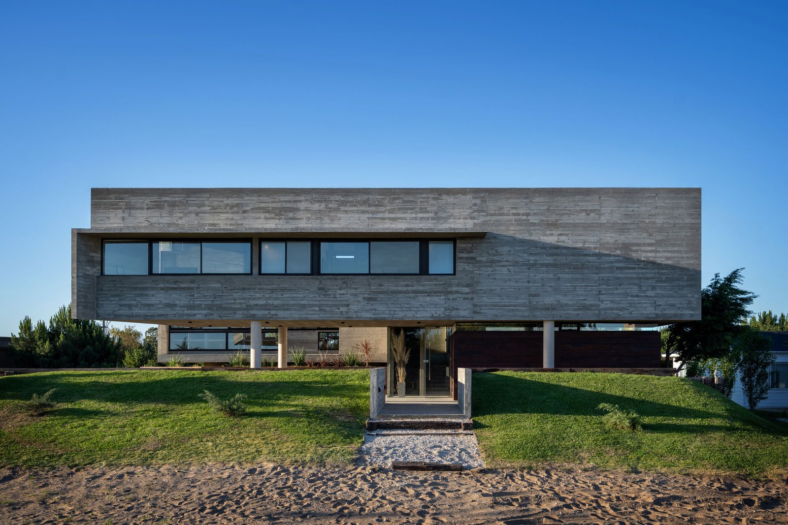 Casa moderna com balanço de concreto e janelas amplas — projeto Casa La Marina, por Besonías Almeida arquitectos, em X6VF+67