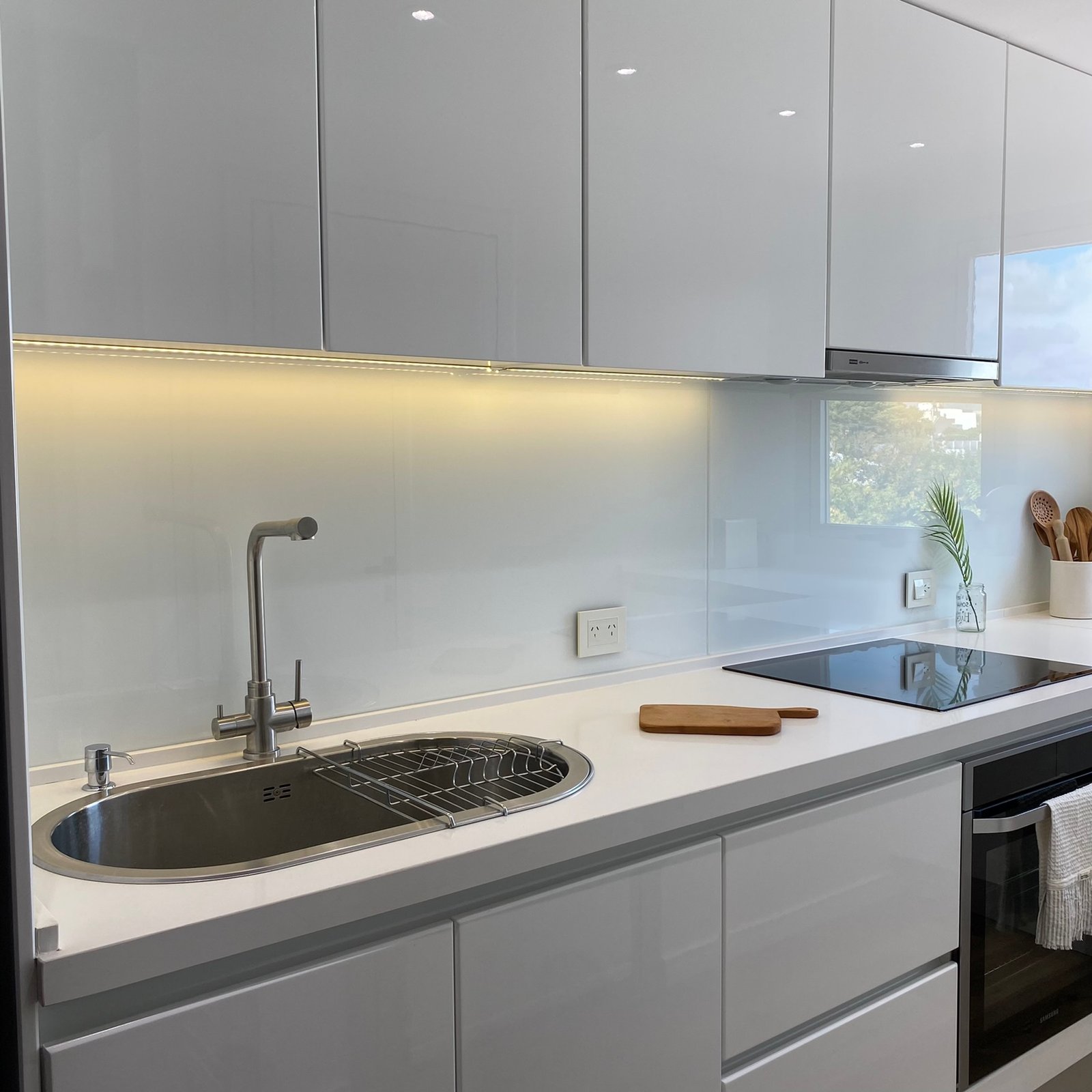 Cocina moderna minimalista con iluminación integrada y acabados blancos — proyecto Burela, por MDBK Arquitectura, en Villa Urquiza