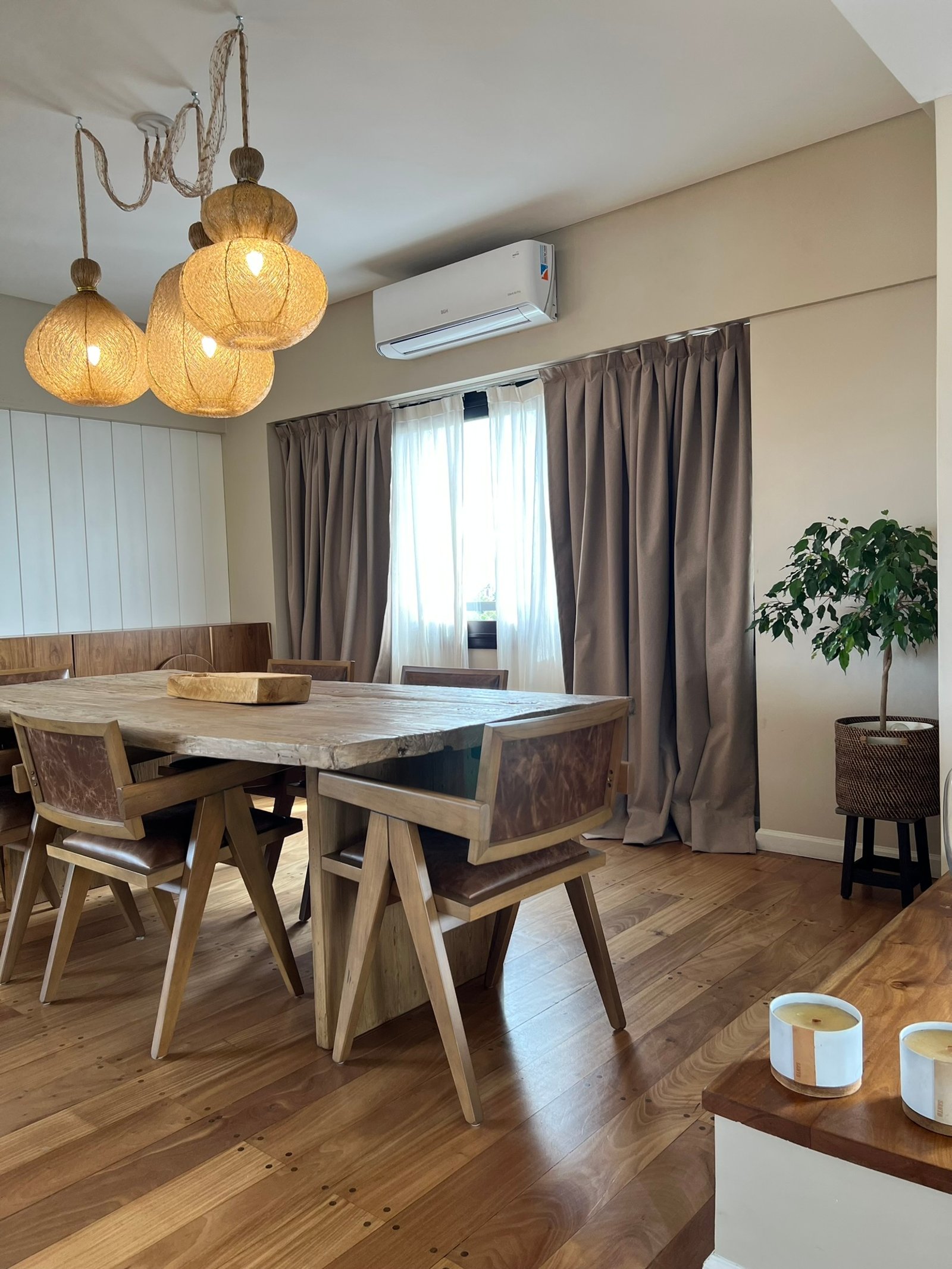 Comedor rústico con mesa de madera y luces de mimbre — proyecto Vallejos, por MDBK Arquitectura, en Villa Devoto
