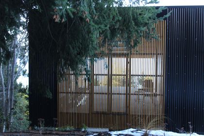 fachada moderna con celosía de madera y metal oscuro — proyecto Casa Península San Pedro, por Servente Larrazabal Arq, en Bariloche