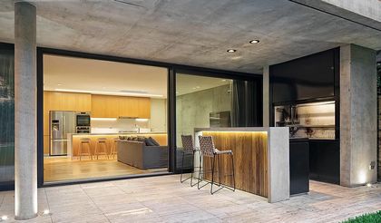 Cocina exterior moderna con isla de hormigón y madera — proyecto Casa Ruas, por Estudio Ramos