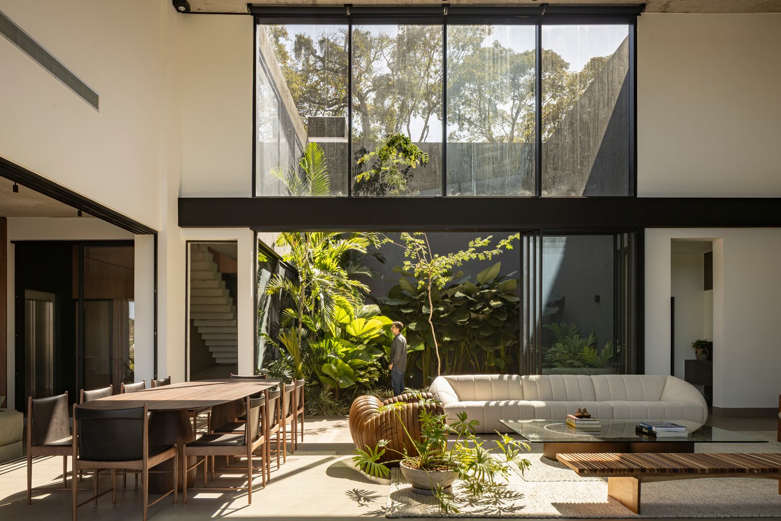 Living moderno con jardín interior y ventanales amplios — proyecto Casa Concreto, por dayala e rafael arquitetos associados, en Goiânia