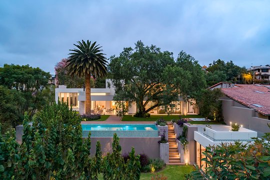 fachada moderna con piscina y vegetación exuberante — proyecto Casa Molle, por MUCHTEK, en Cumbayá
