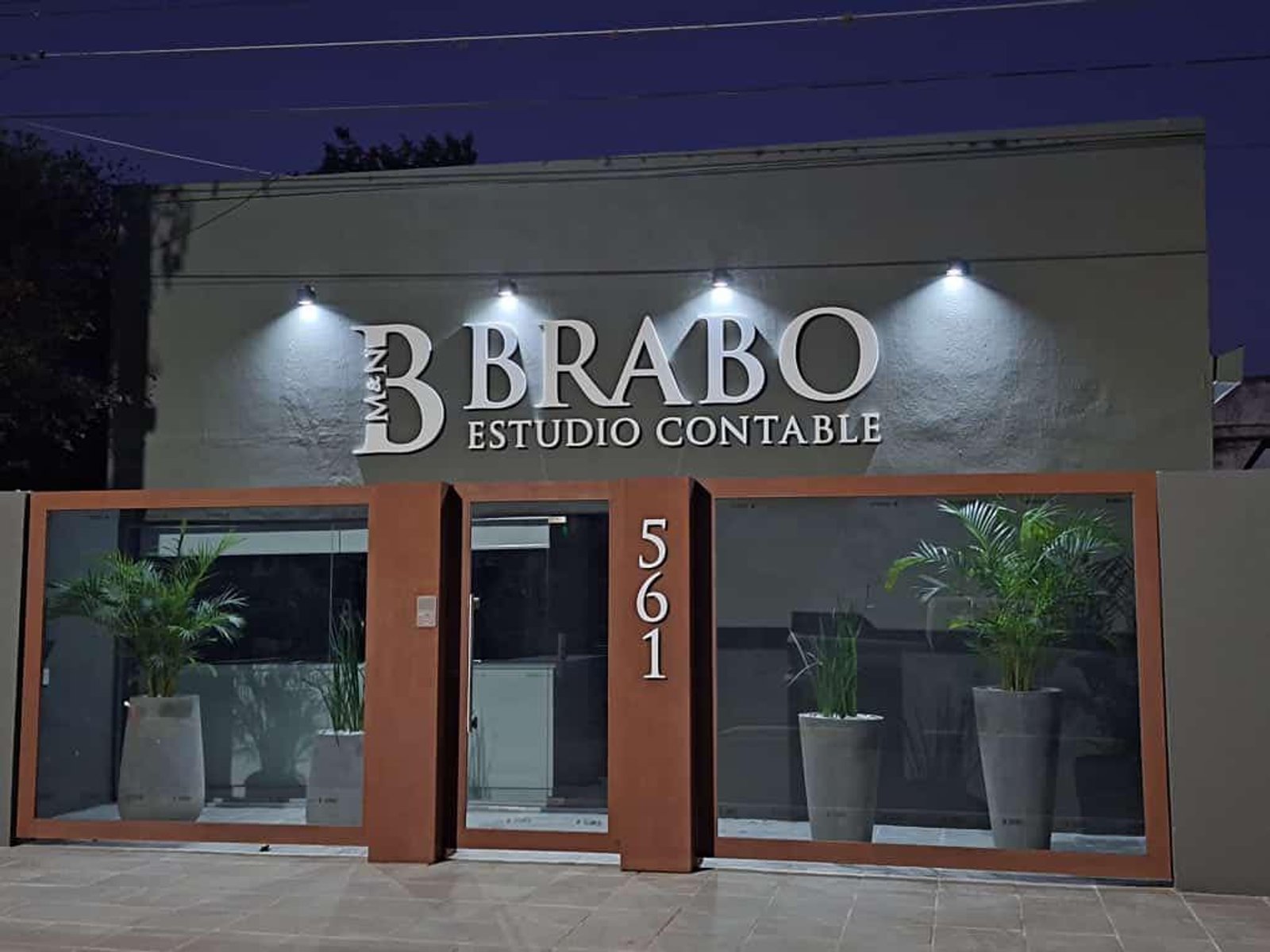 fachada de oficina moderna con cartel luminoso y plantas — proyecto Esudio Contable, por Arquitecto Gustavo Maidana, en Caá Catí