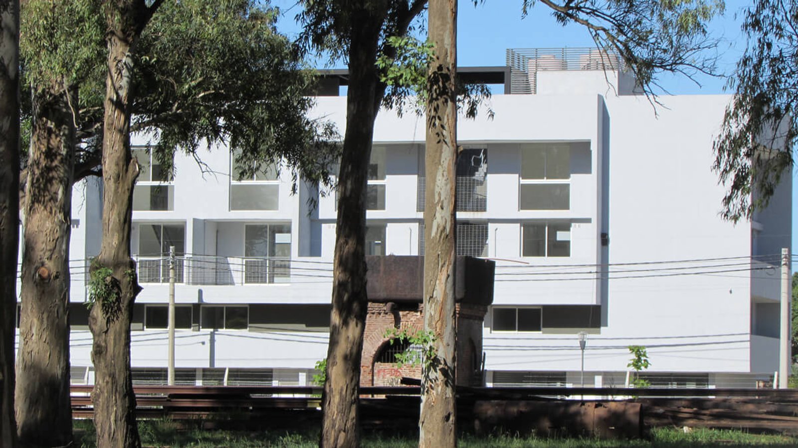 Edifício moderno com fachadas brancas e grandes janelas — projeto Plan de viviendas Santa Fe, por PROTEX, em Baigorria