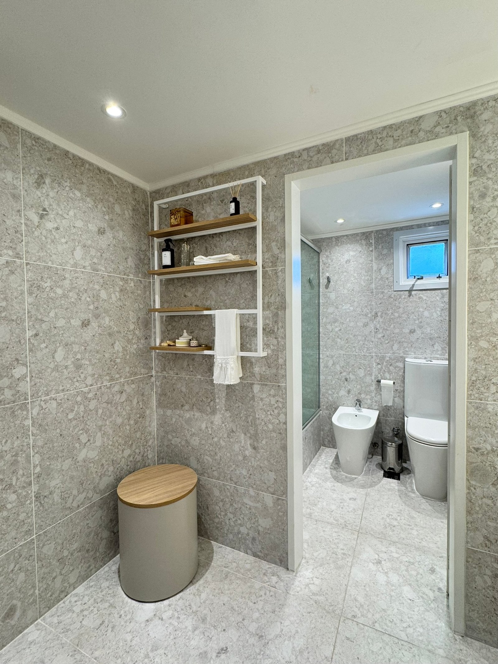 Baño moderno con azulejos grises, estantería de madera y bidet — proyecto Lafinur, por MDBK Arquitectura, en Palermo