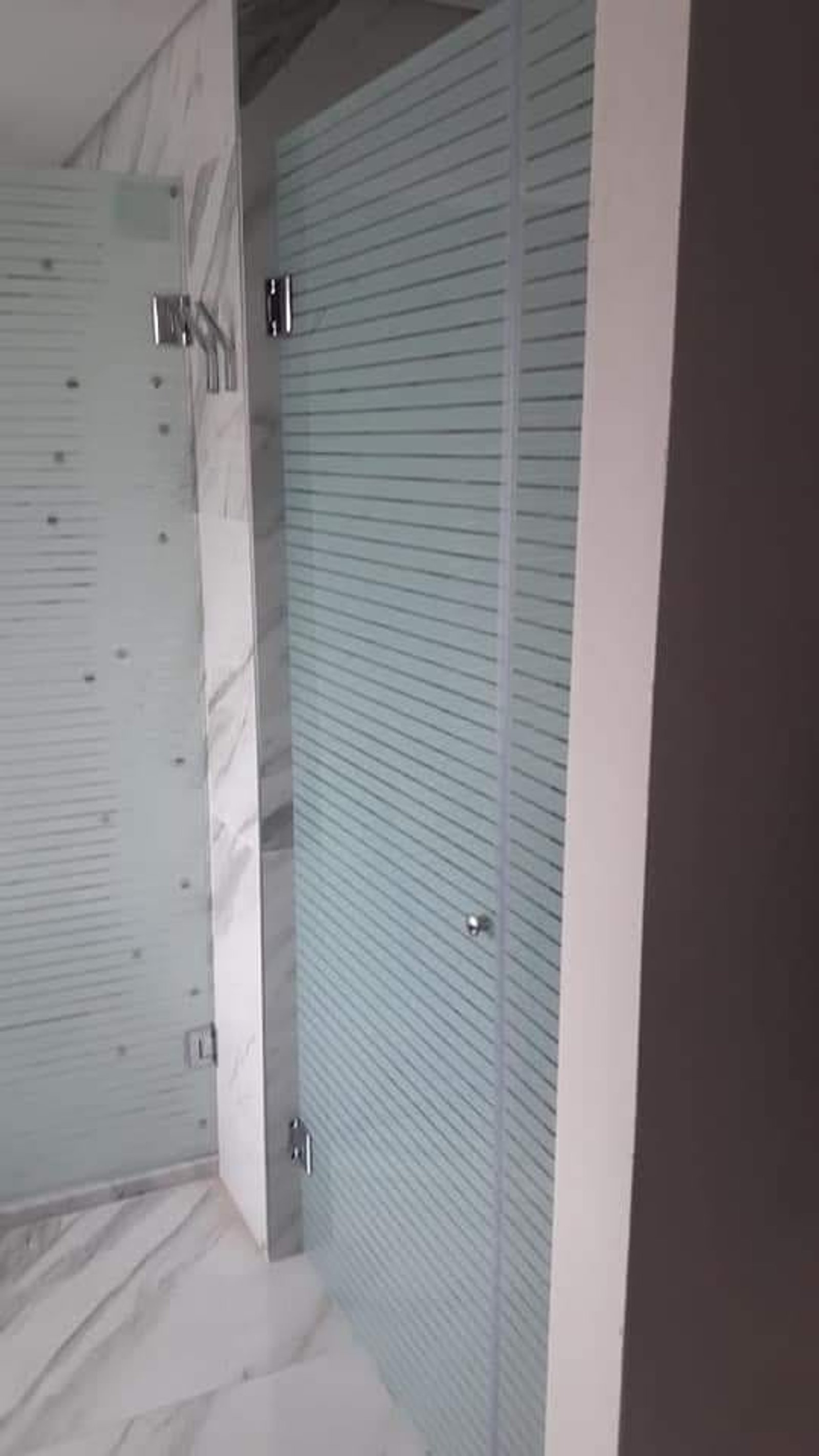 Baño moderno con mampara de vidrio rayado y suelo de mármol — proyecto Mamparas varias , por Cristalcenter, en San Vicente