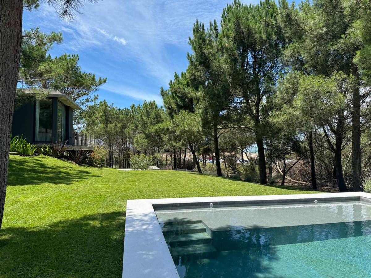 Piscina moderna em floresta com fachada envidraçada — projeto Casa CE, por Estudio FORSCH, em Pinamar