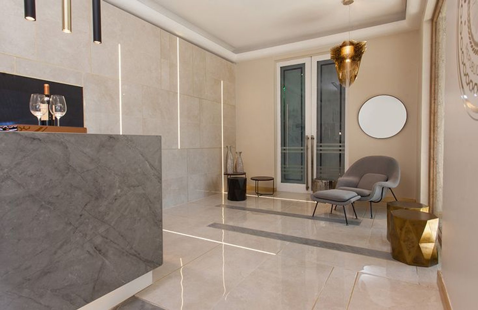 Recepção moderna com poltrona curva e detalhes dourados — projeto Casa Foa Circulo Olivos 2019, por Vite Porcellanato, em La Lucila