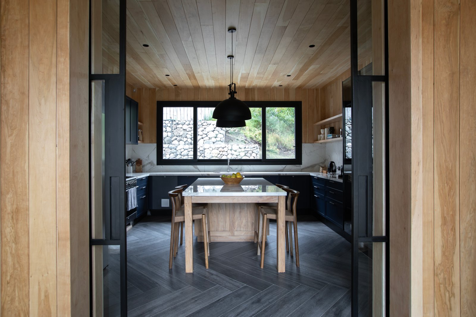 Cocina moderna de madera con isla y ventanales al campo — proyecto OBRA SANTA BARBARA, por ILVA, en Provincia de Buenos Aires