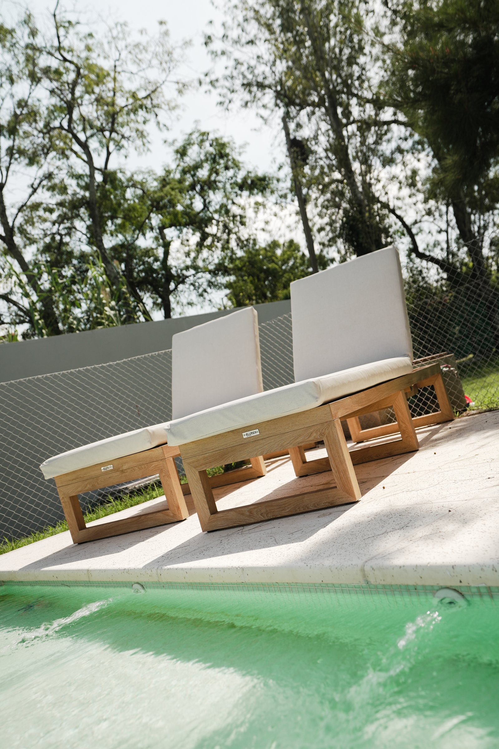 Reposeras de madera modernas junto a la piscina — proyecto Exteriores, por CASA1-TROMEN, en Bella Vista