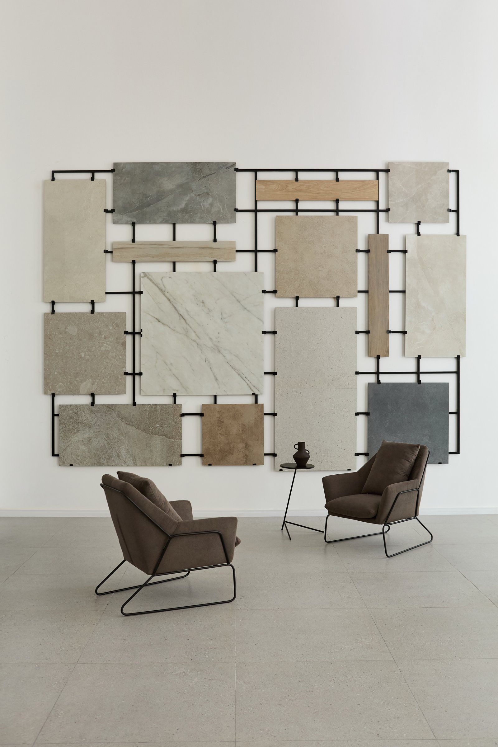 Interior moderno con exhibición de azulejos y sillones grises — proyecto Showroom, por San Lorenzo Design, en Buenos Aires