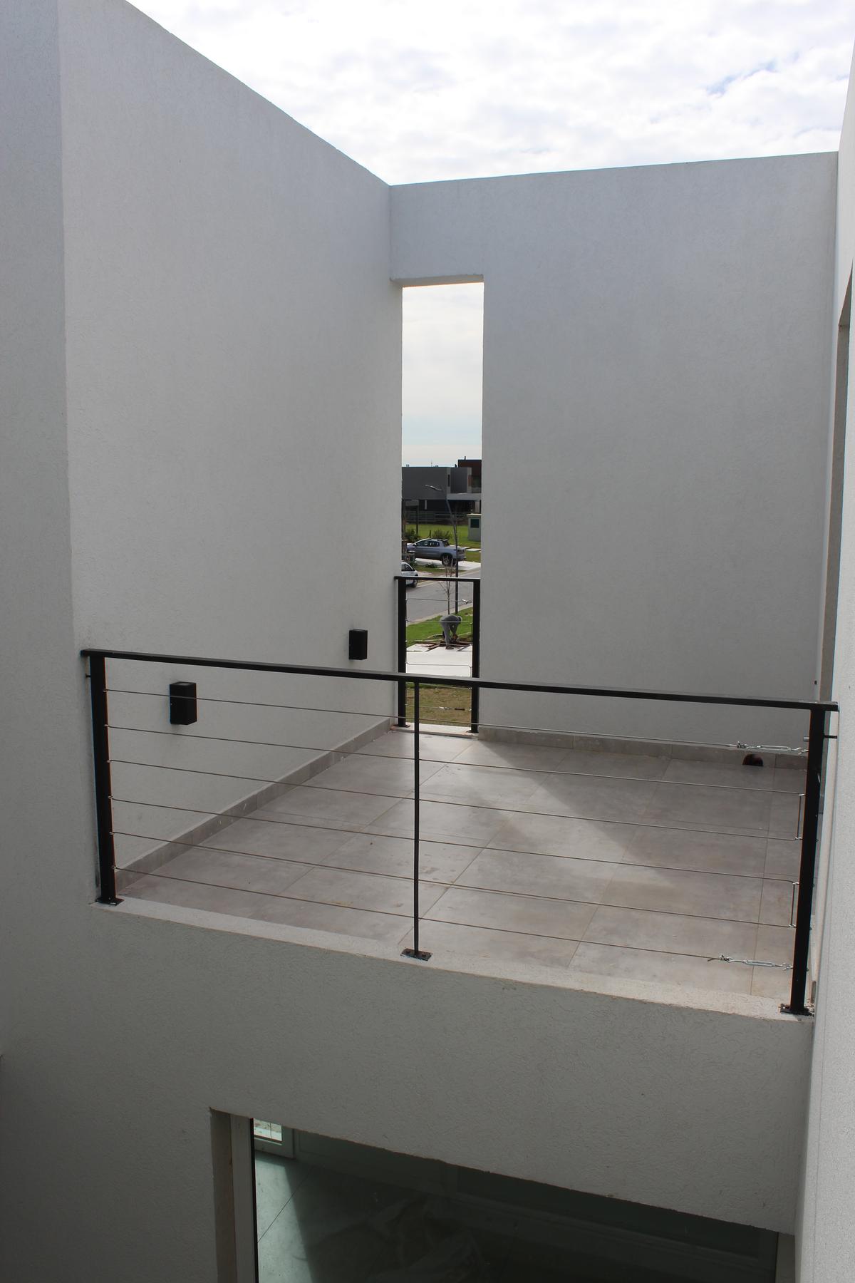 Varanda moderna com vista para bairro residencial — projeto Carpinchos 3, por CASTRO SANCHEZ ARQUITECTOS, em B1648 Tigre