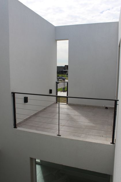 Balcón moderno con vista a barrio residencial — proyecto Carpinchos 3, por CASTRO SANCHEZ ARQUITECTOS, en B1648 Tigre