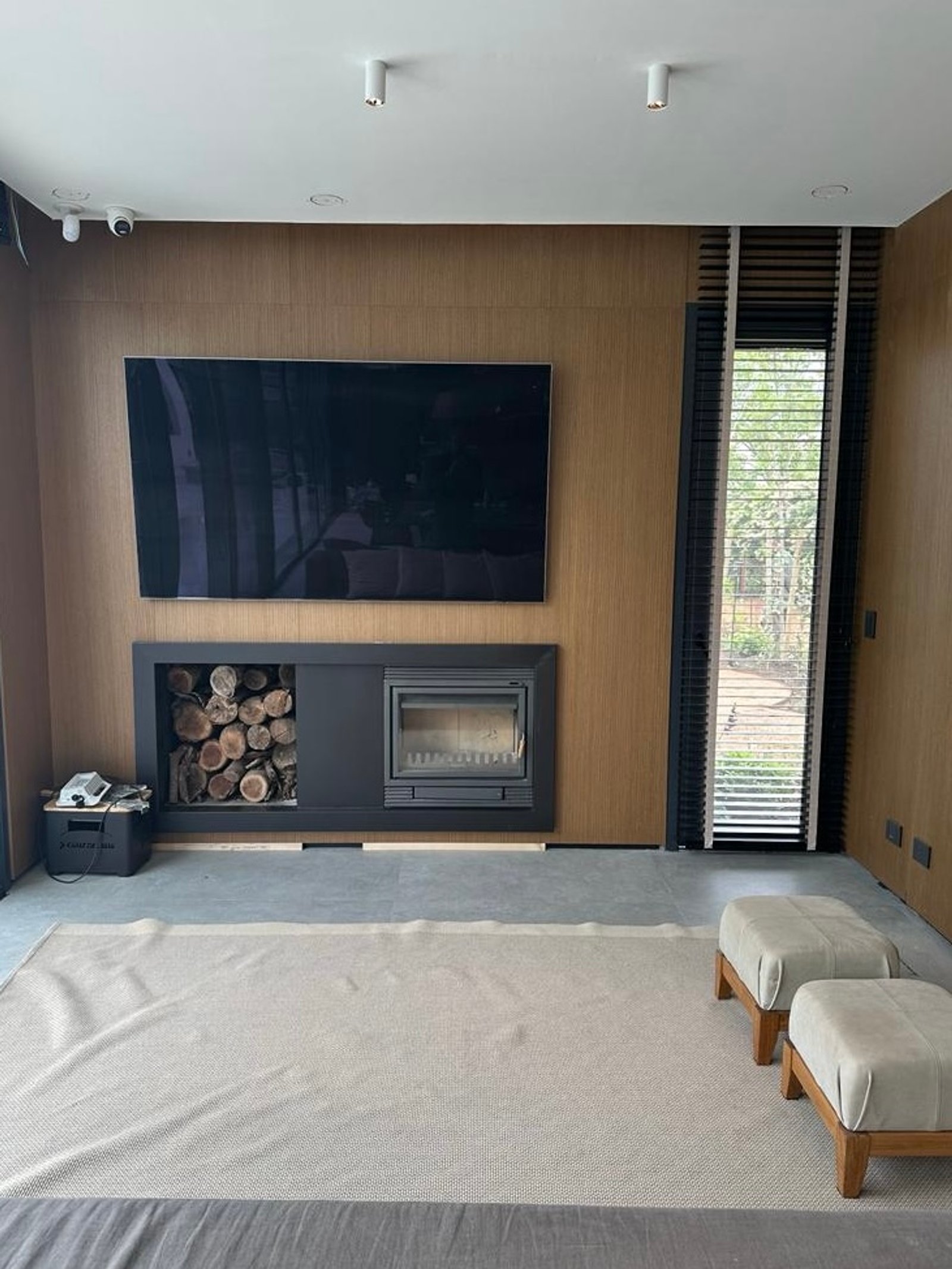 Living moderno con chimenea y paneles de madera — proyecto Pacheco Golf - Estudio Etiqueta, por ABEJA CONCEPT, en Gral. Pacheco