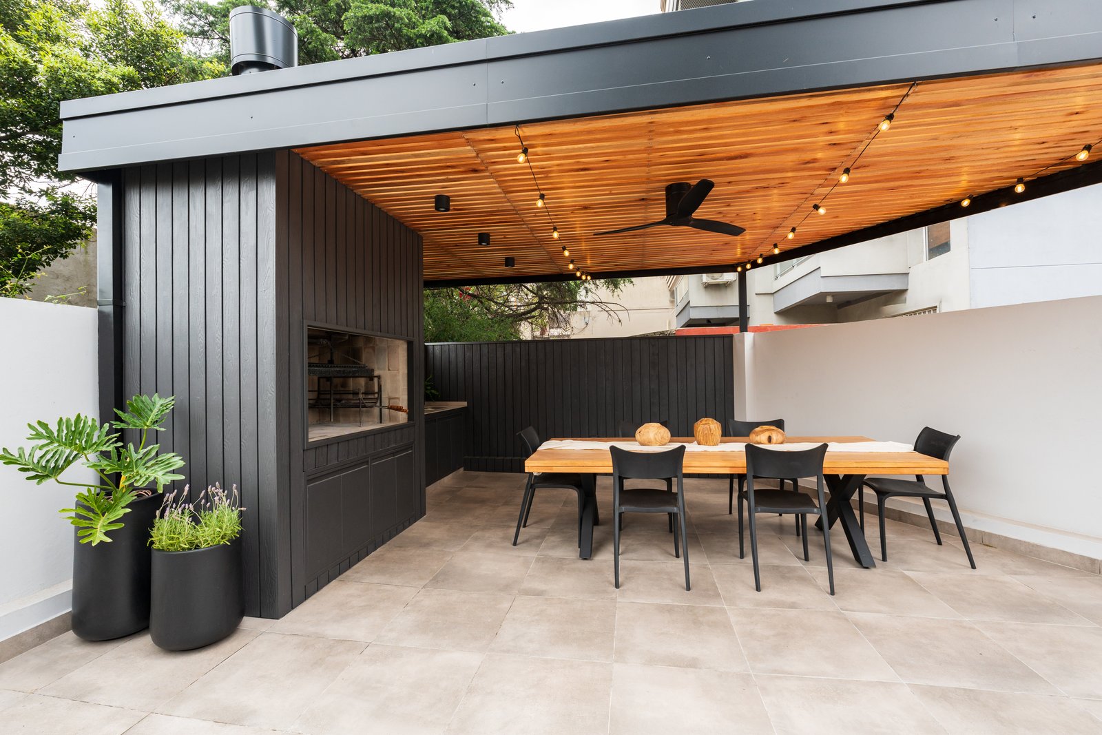 Comedor exterior moderno bajo pérgola de madera con parrilla — proyecto TERRAZA MARCOS SASTRE, por FARQ ESTUDIO, en Villa del Parque