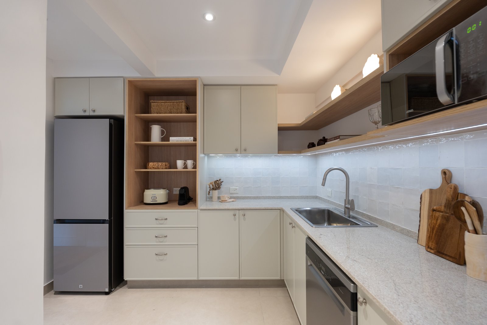 Cocina moderna con muebles blancos, estantes de madera y encimera de piedra — proyecto Balbín, por Estudio BDM, en Av. Dr. Ricardo Balbín 2447