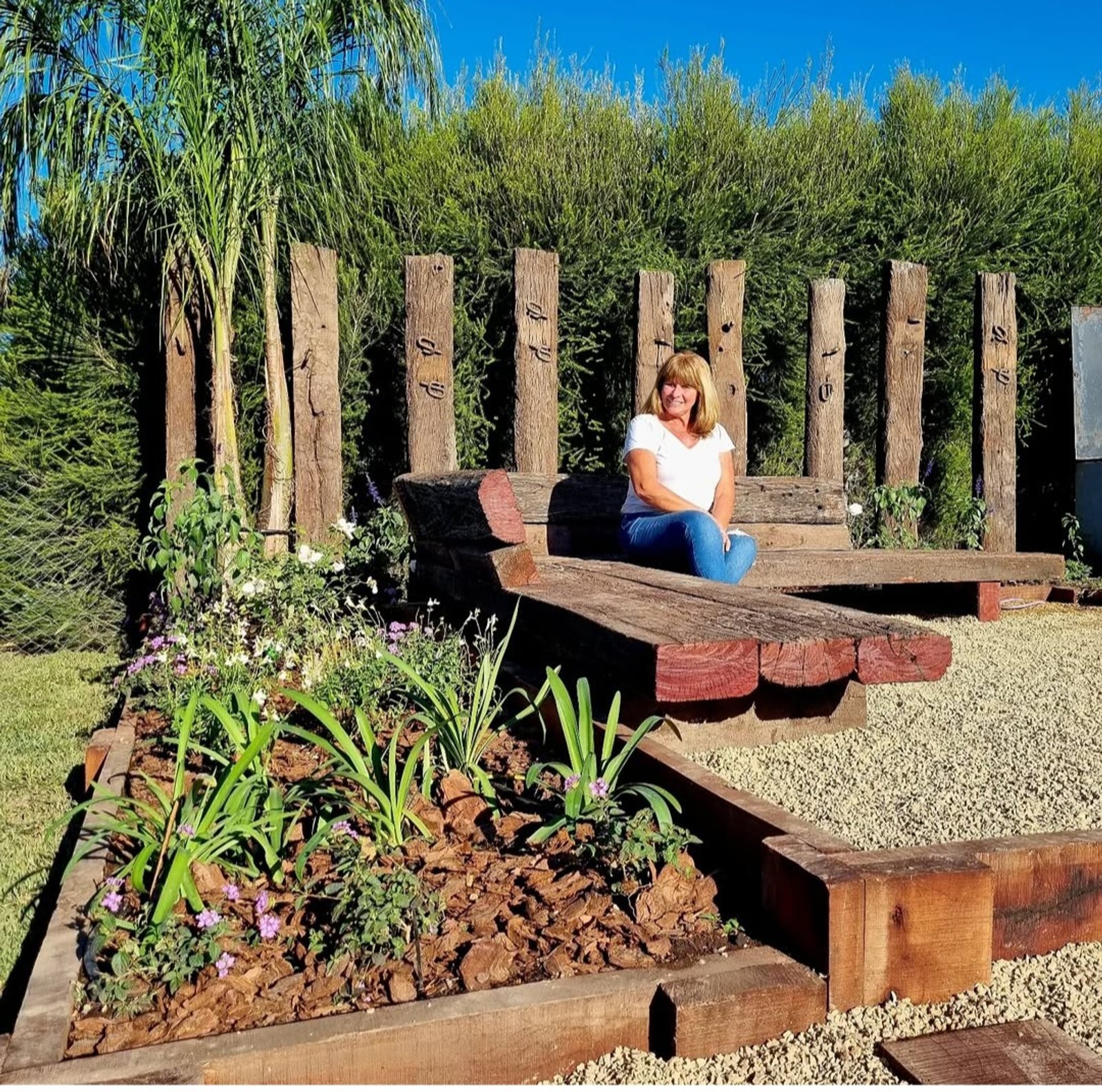 Patio rústico con deck de madera y vegetación frondosa — proyecto Barrio El Cantón Islas, por Marcela García Brünner Paisajista, en Calle Libertad 310 and Av. San Martin