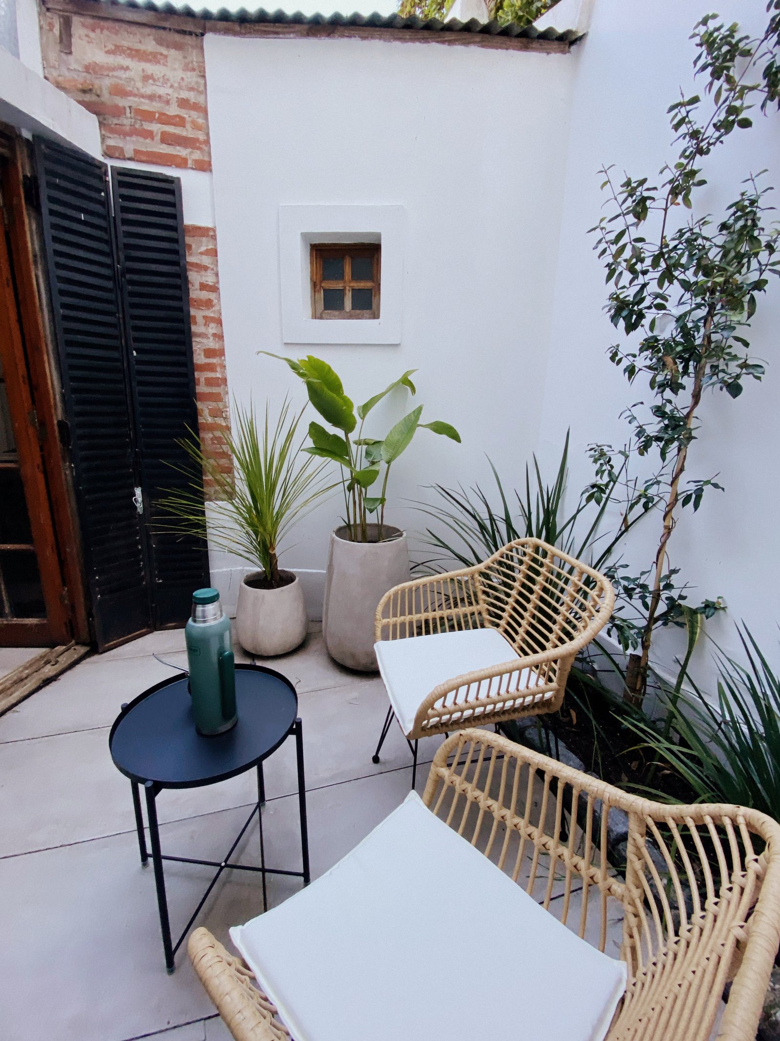 Patio mediterraneo con sillas de mimbre y plantas — proyecto Reforma patio interno Casa, La Plata, por Estudio cardo, en C. 47 119
