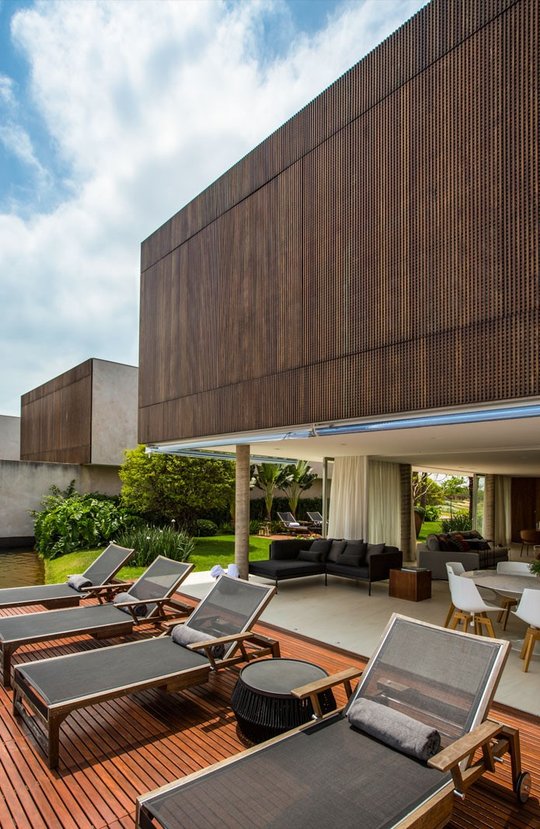 Terraza moderna con deck de madera, deck chairs y zona cubierta — proyecto Arquitetura e Interiores II, por Demian Golovaty