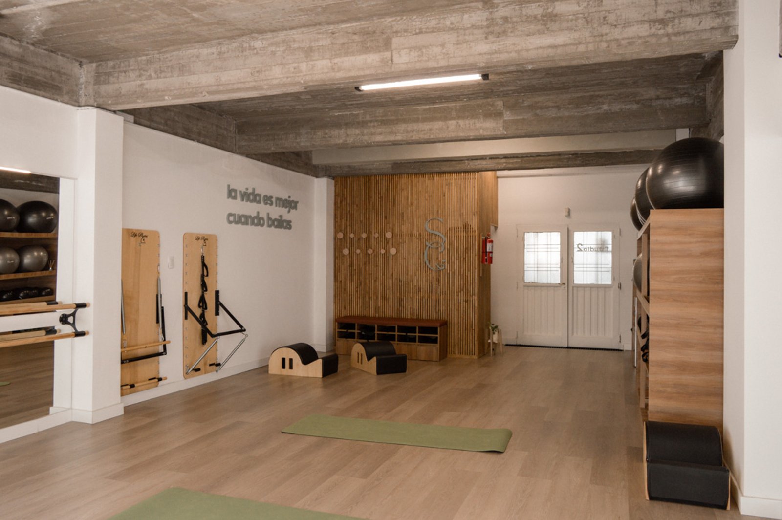 Estudio de pilates con vigas expuestas y piso de madera — proyecto Estudio Integral SC - Tandil, por Estudio Agustina Satostegui, en Tandil