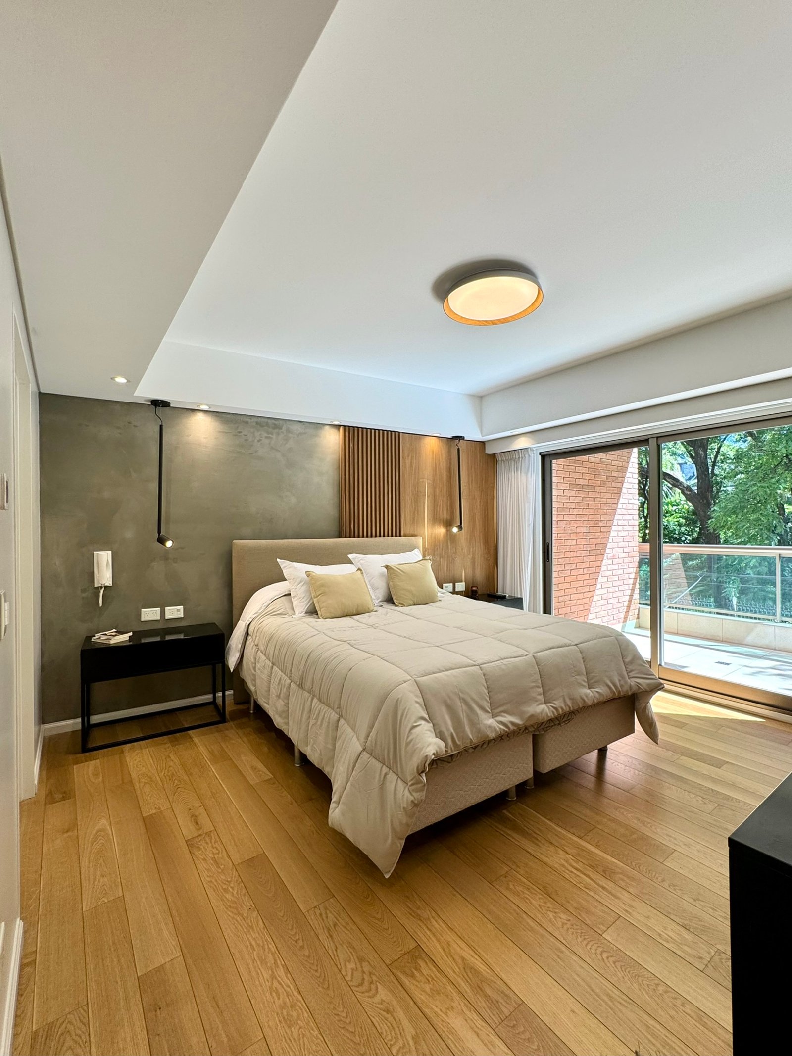 Dormitorio moderno con cama grande, suelo de madera y luz indirecta — proyecto Olleros, por MDBK Arquitectura, en Belgrano