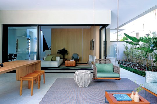 Amplio living moderno con paredes de madera y grandes ventanales al jardín — proyecto Projeto Destaque Club&Casa, por Barbara Dundes – Arquitetura + Design
