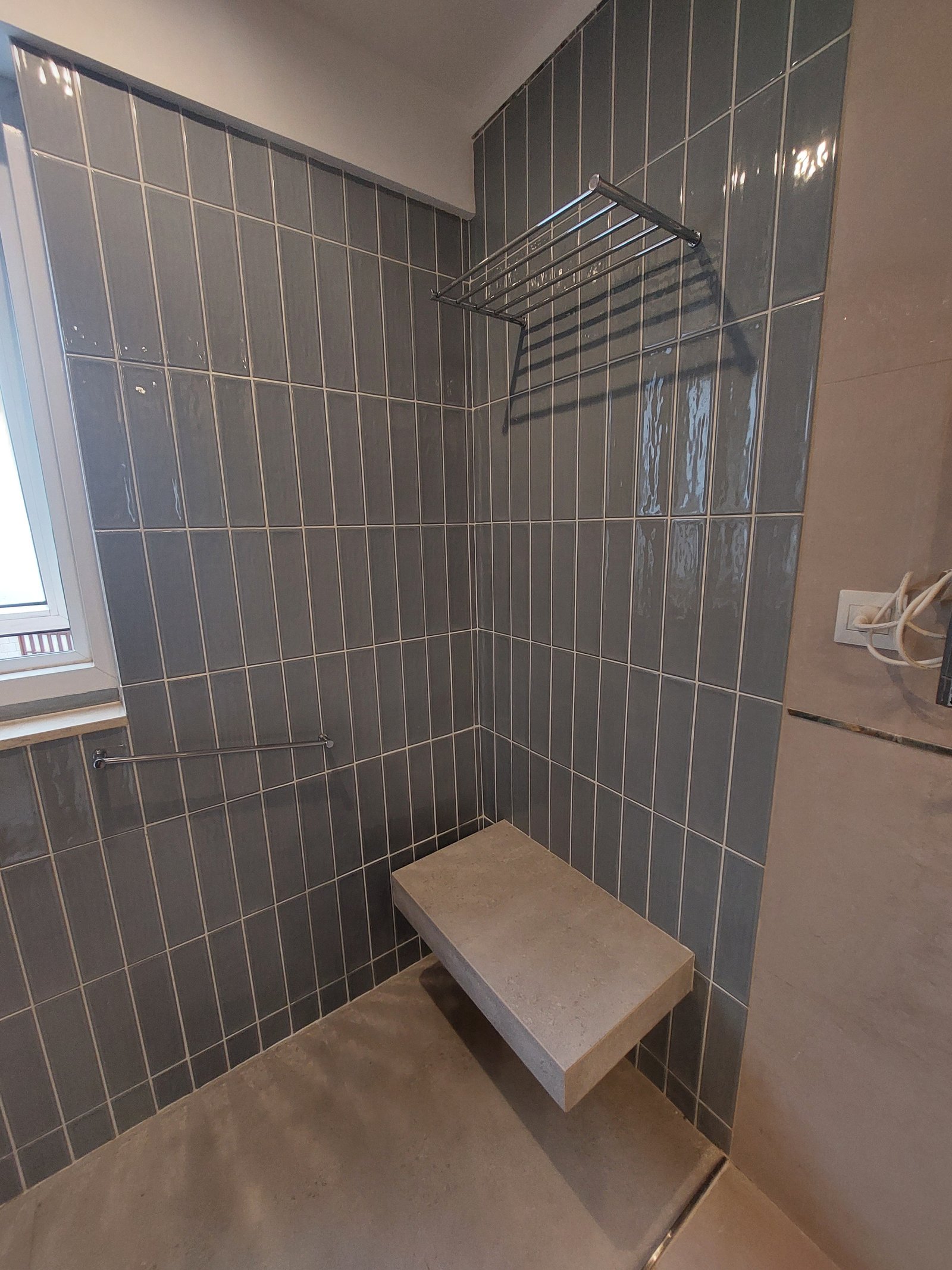Baño moderno con ducha, banco empotrado y azulejos verticales grises — proyecto CONESA, por Arquitecta, en Belgrano R
