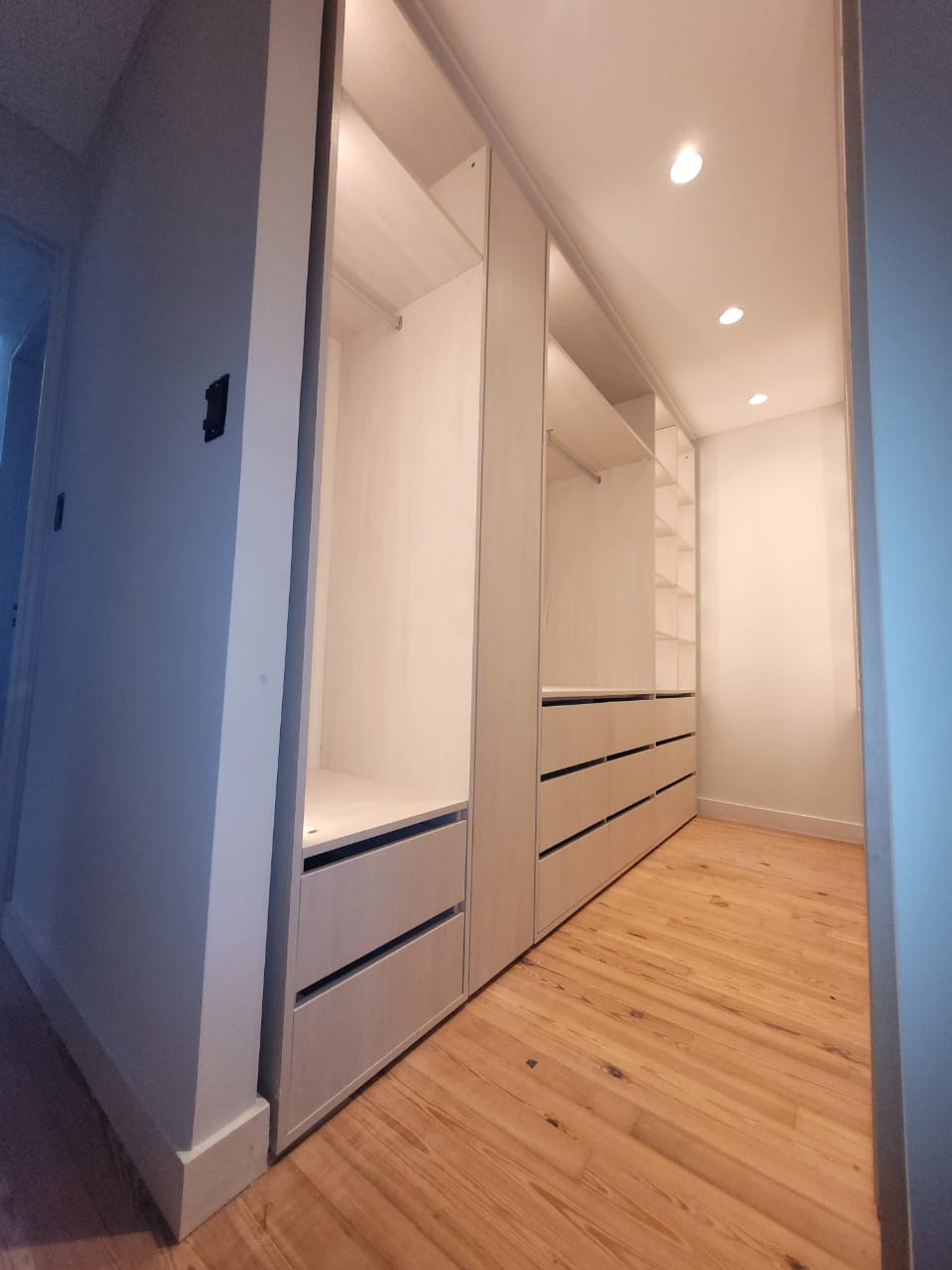 Interior de vestidor moderno con almacenamiento integrado y suelo de madera — proyecto Belgrano, por Licefe Carpentry SRL, en Belgrano